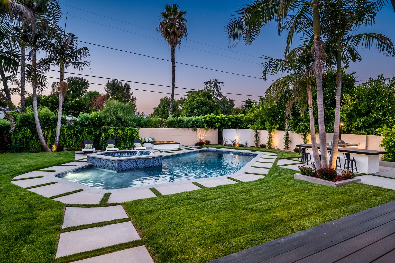 A backyard pool in a verdant garden setting in a modern new construction home in Los Angeles