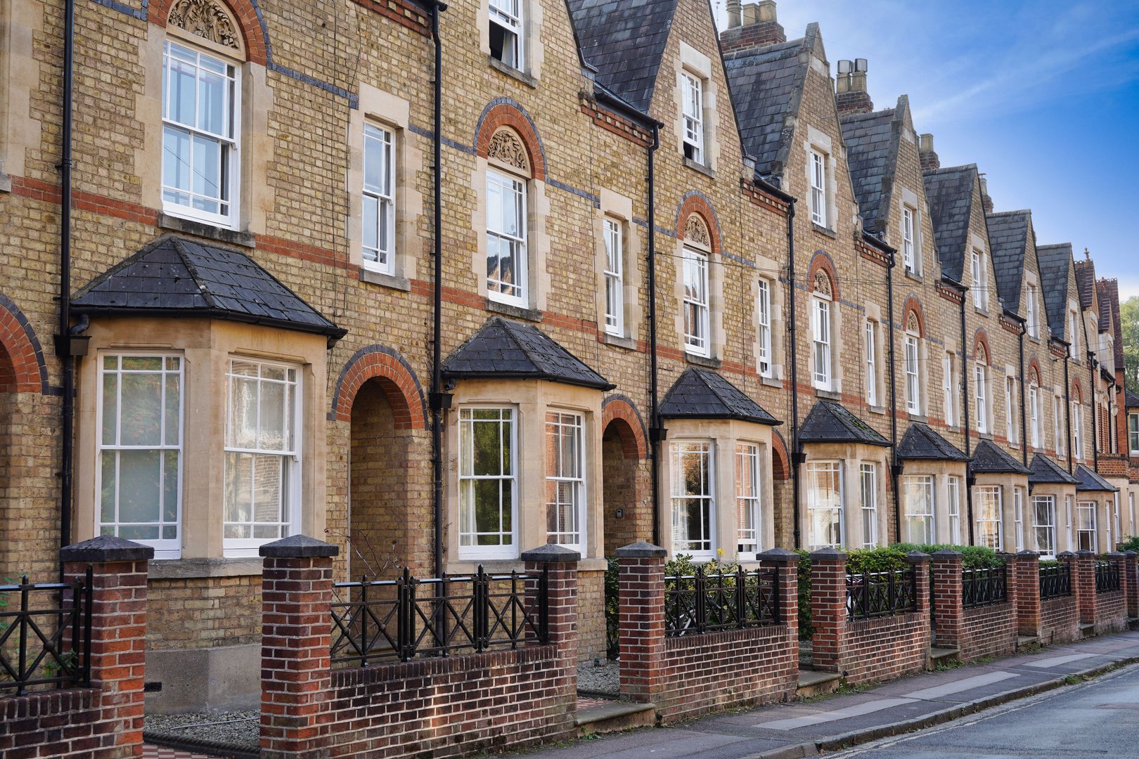 Row of modest brick English suburban homes with gables