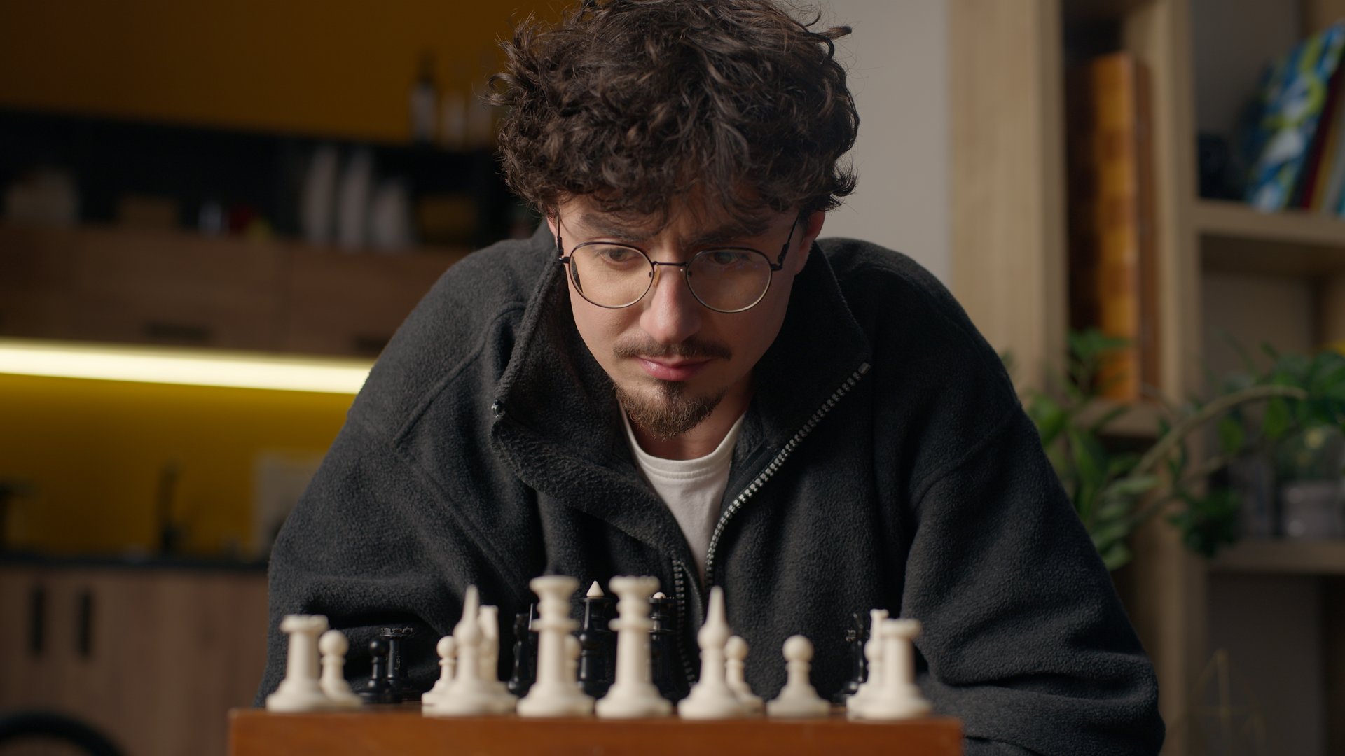 Focused Hispanic guy player playing chess mind game at home hipster look chessboard thinking brainstorm strategy grandmaster male practicing for tournament intellectual sport man moving bishop piece. High quality 4k footage