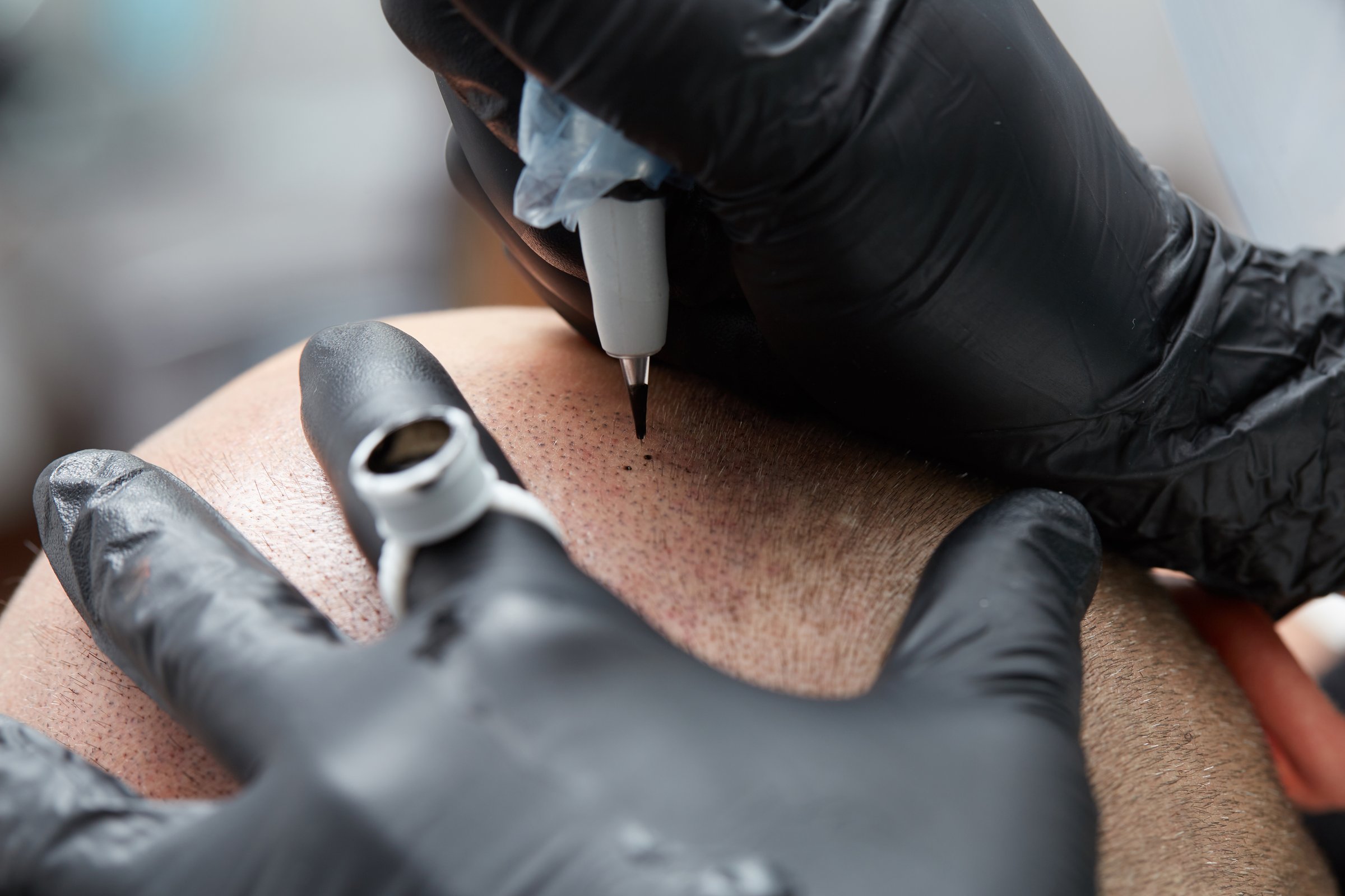 Cosmetologist making permanent makeup on man head - tricopigmentation