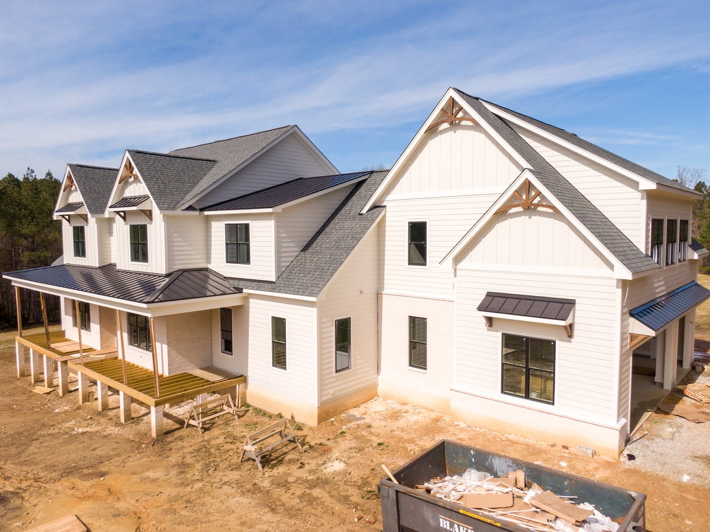 Drone aerial image of a custom residential home under construction featuring mixed roofing materials
