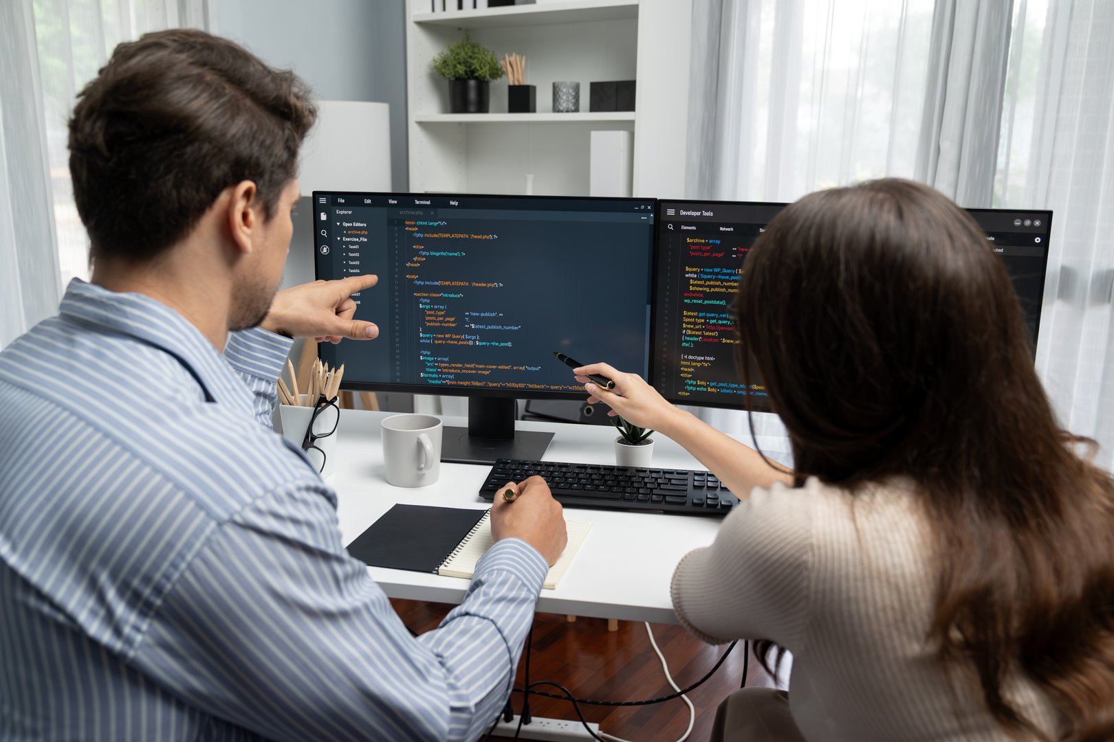 Team skilled developers program coding discussing creative website planning software project on two screen monitor's full stack data analyzing design at office with back side view concept. Postulate.