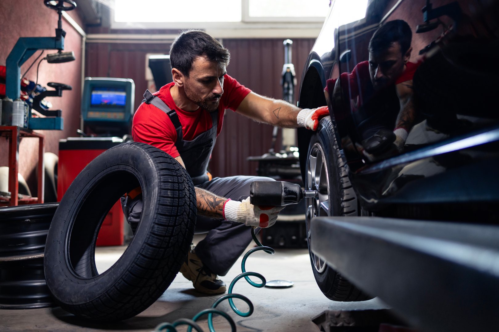 Wheel repairman using tool to remove damaged tire from the car.
