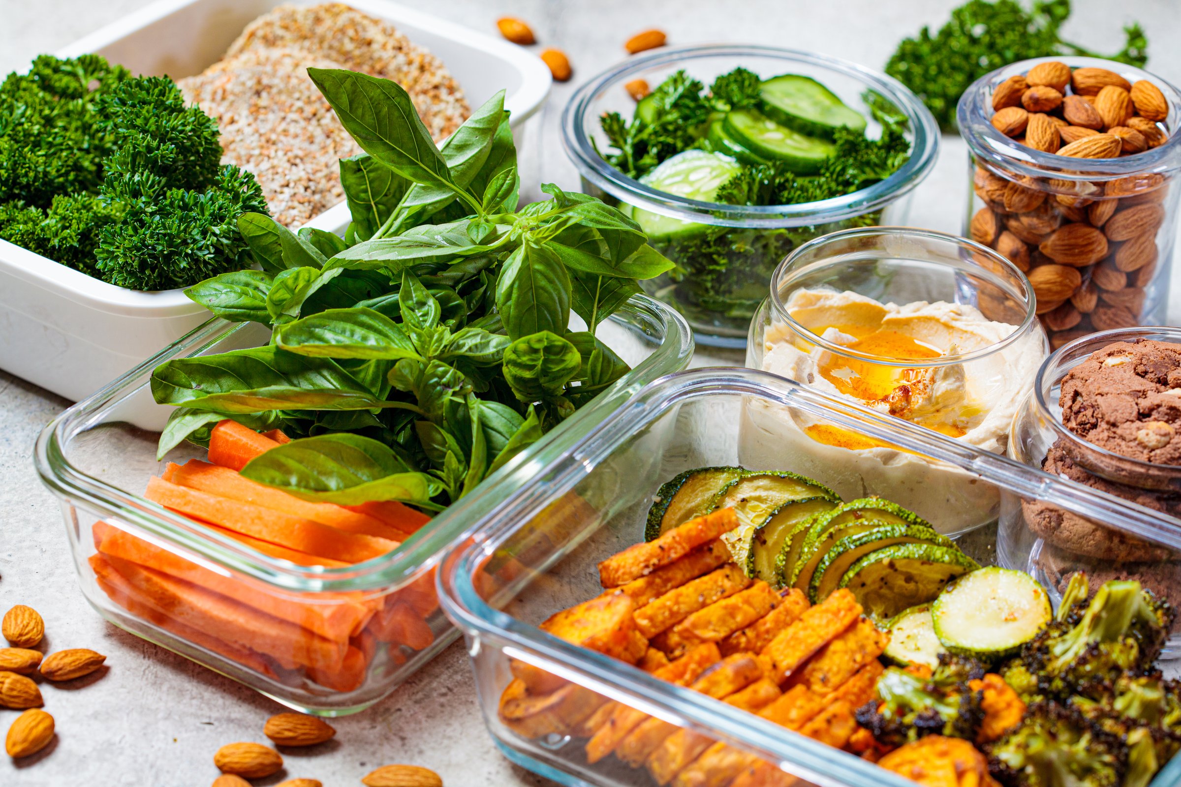 Preparing healthy meals for the week. Vegan food and snacks in containers, gray background. Flat lay cooking food.