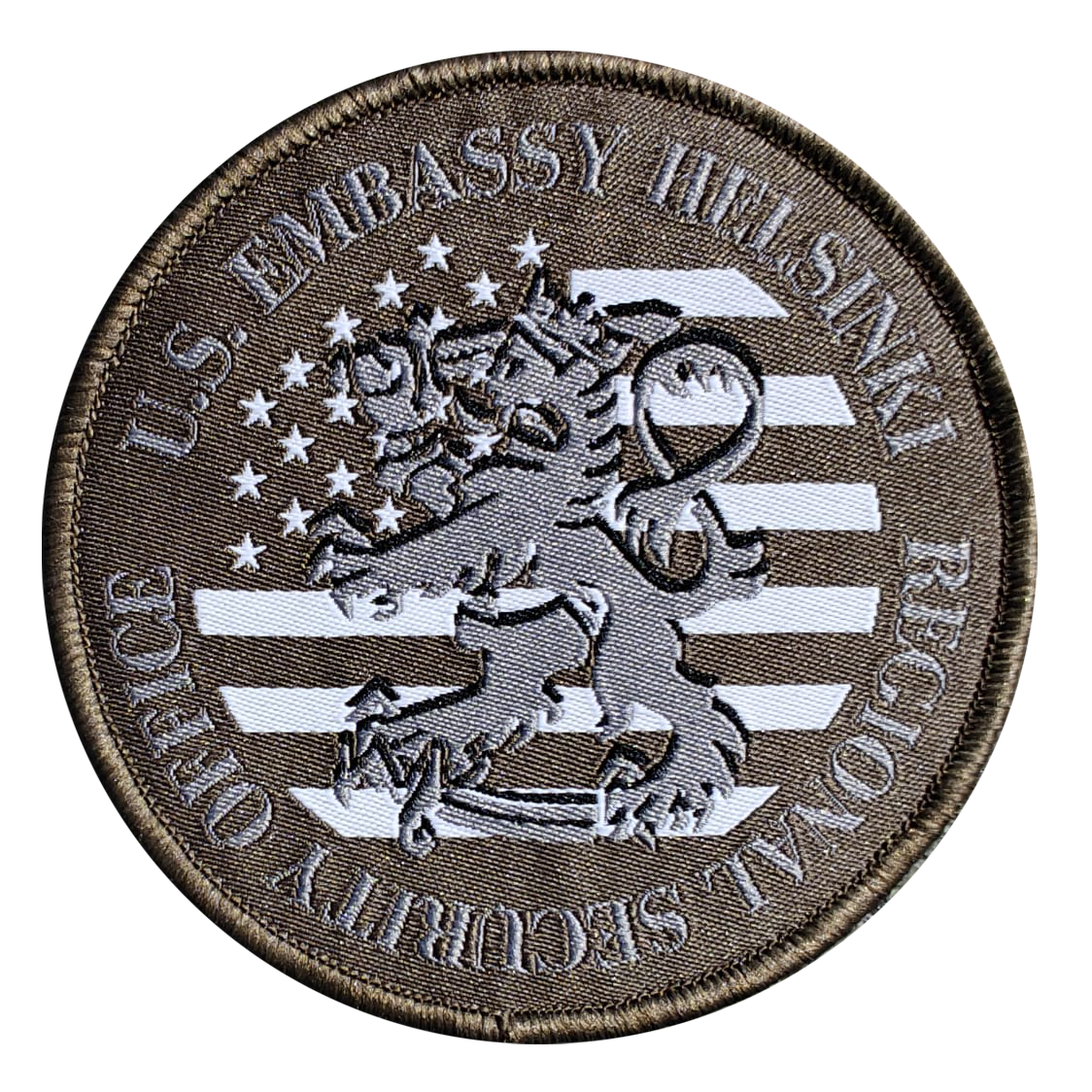 Patch reads U.S. Embassy Helsinki Regional Security Office, featuring lion and stars on brown background with gray stripes.