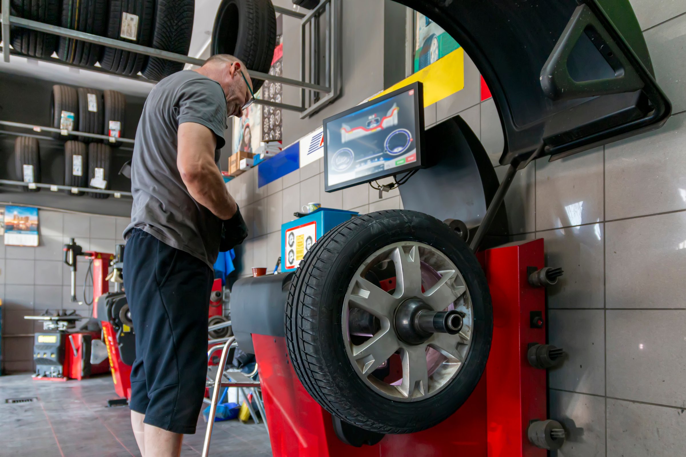 Car wheels maintenance. Expert tire repair and replacement at trusted vulcanization point with reliable service. Technical man balancing tires, maintenance and set the wheel center.