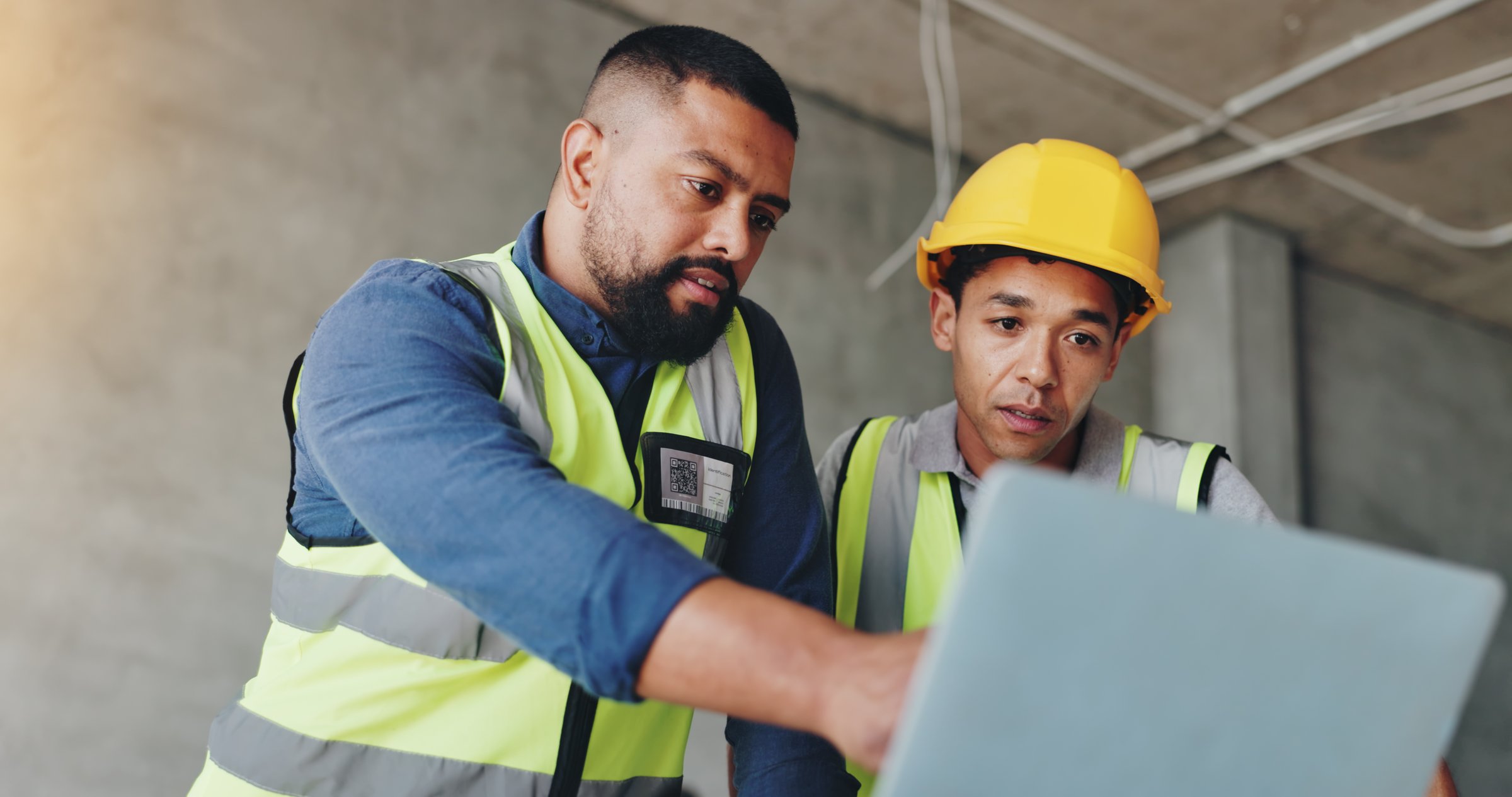 Man, laptop and architect at construction site with discussion, review and team for renovation project. Lead engineer, computer and point with partner, solution or feedback for property development