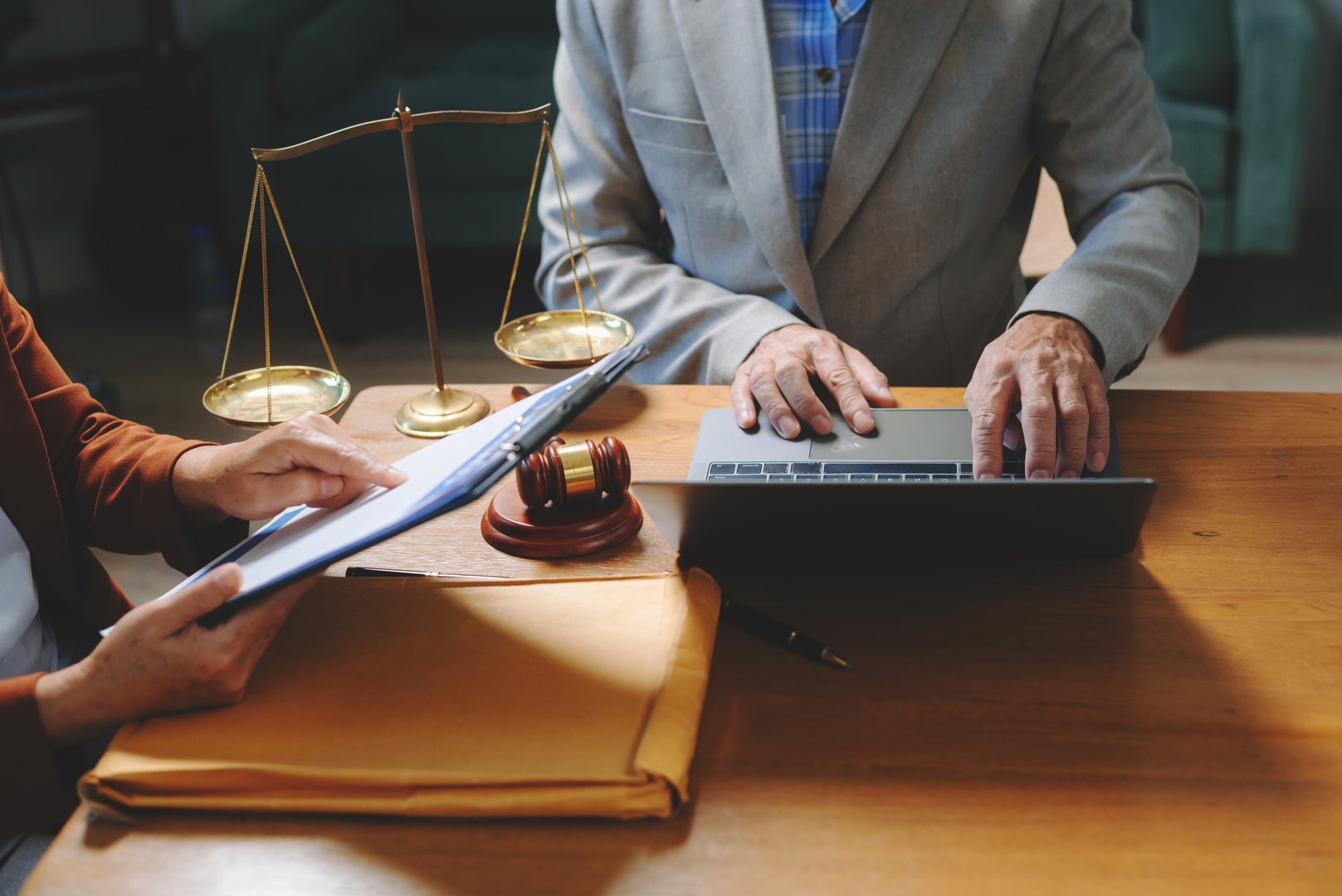 Two lawyers are discussing about contract paper, law matters determination, pointing.law and hammer on the table