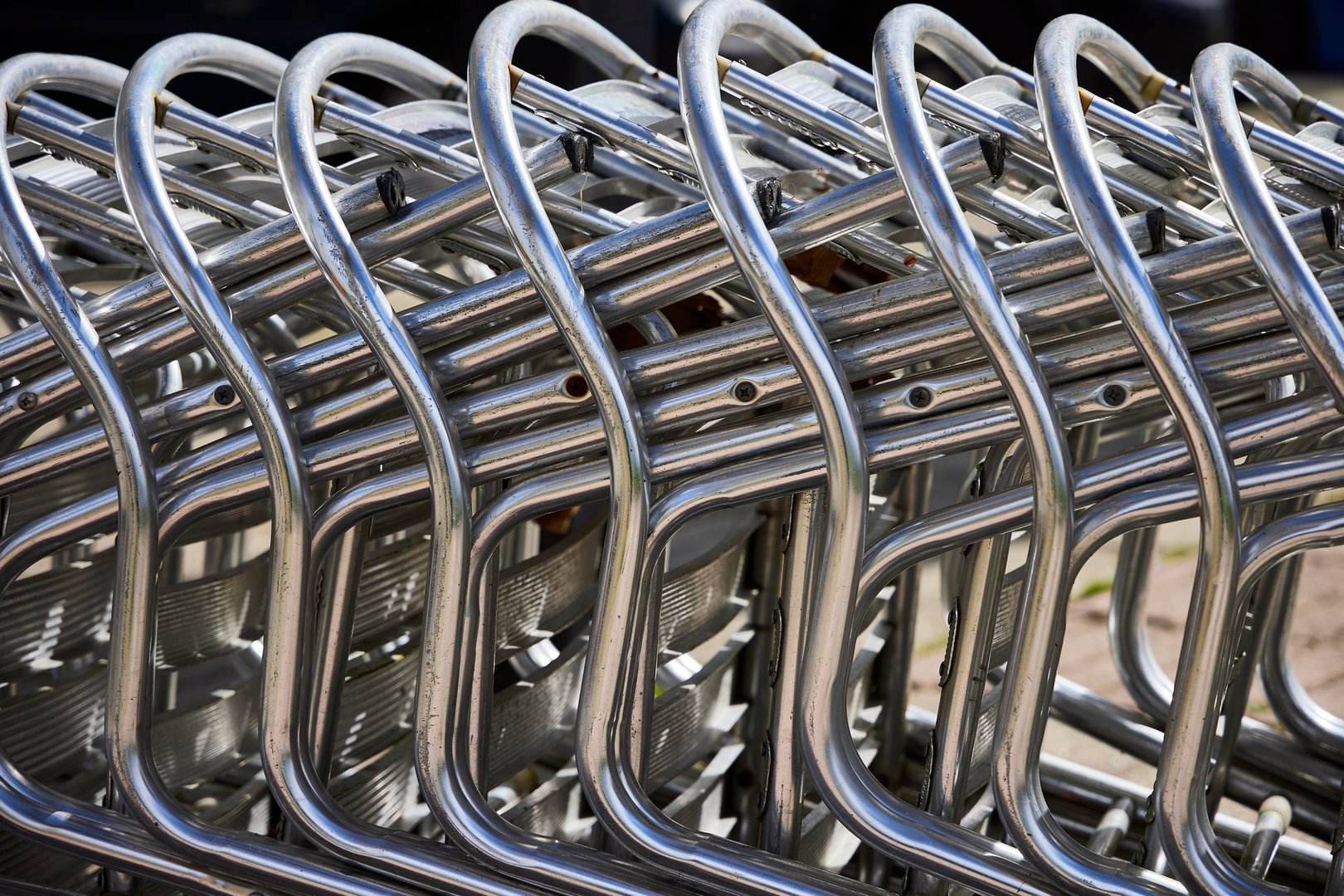 Several metal chairs from a cafe stacked on the street