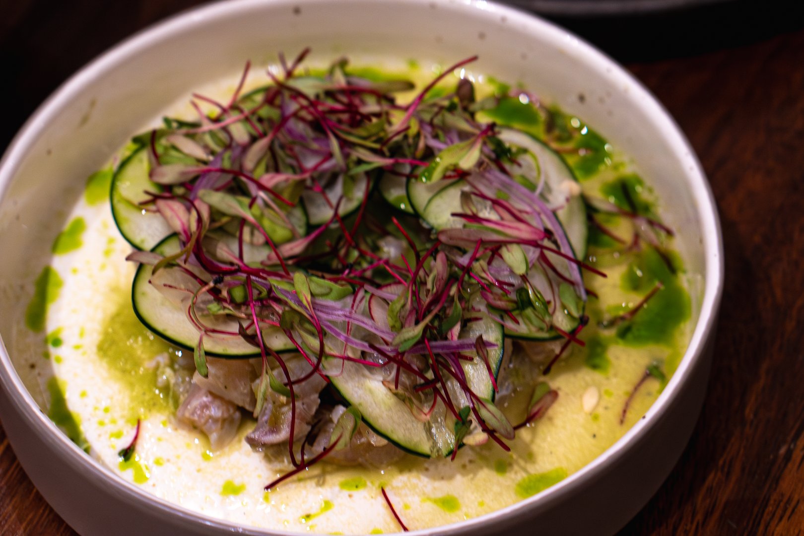 Fresh fish ceviche with cucumber, microgreens, and a vibrant sauce