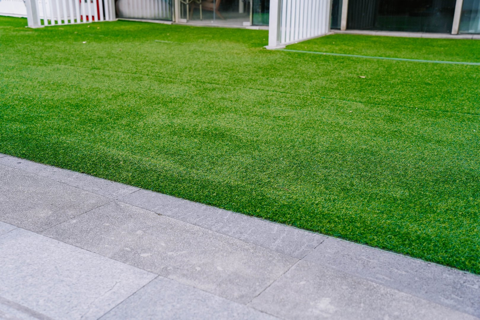 Artificial grass lawn turf in the front yard of a modern building