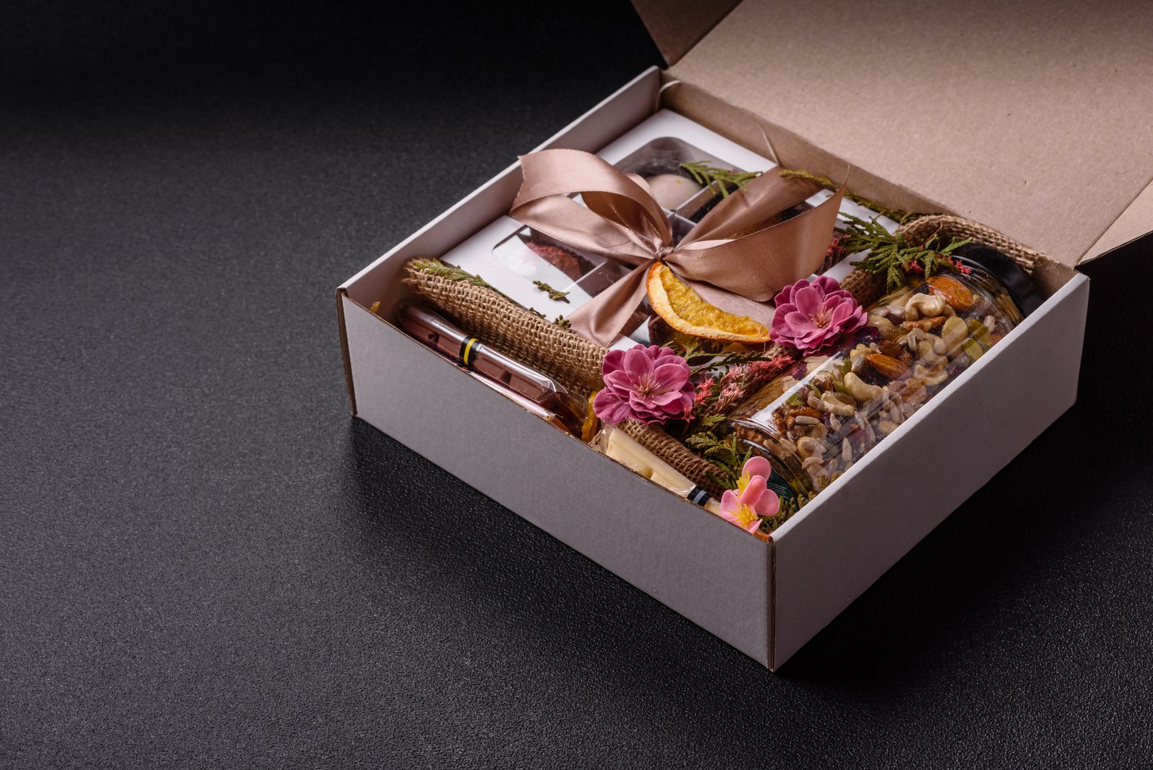 Gift box with a jar of nuts with honey, chocolate and craft candies made at home