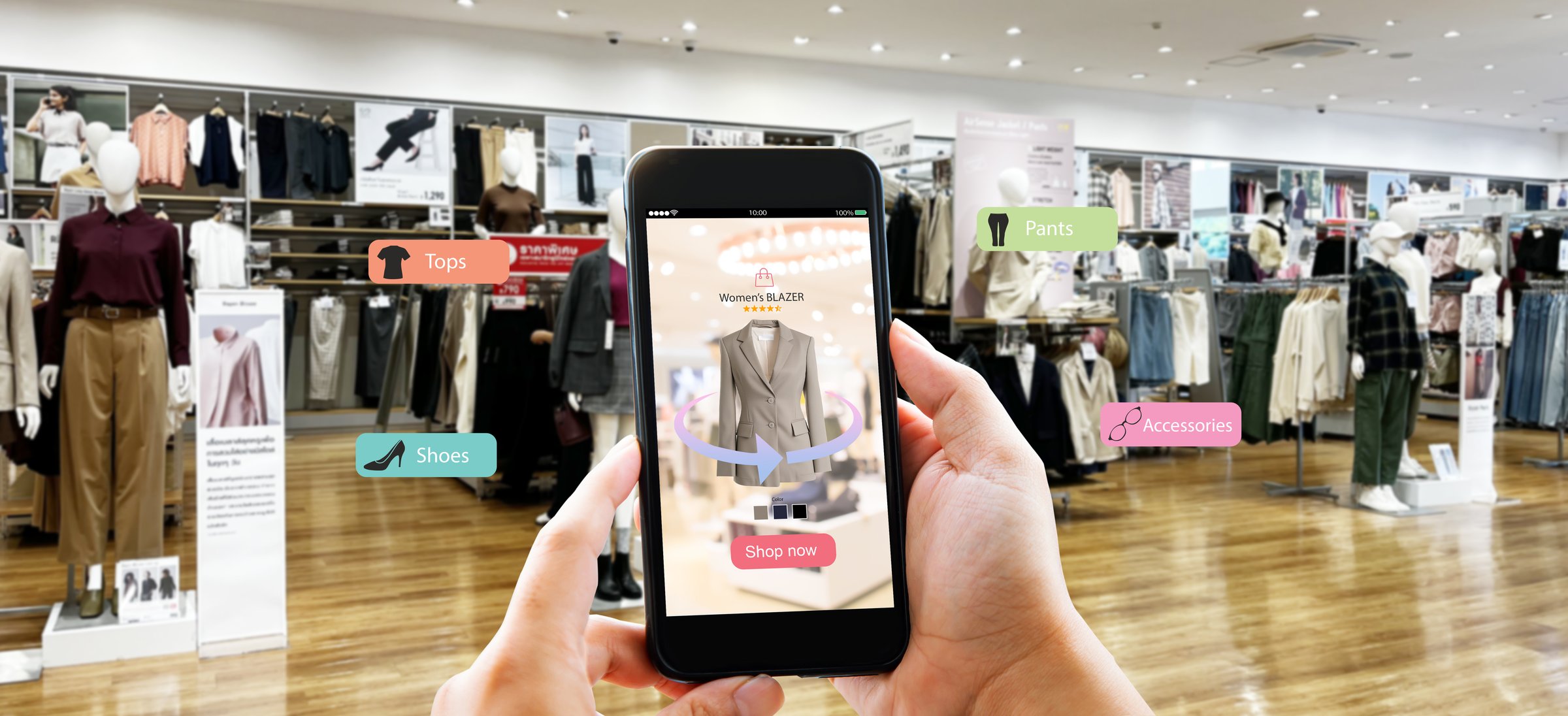 Hands holding mobile phone on blurred fasion store