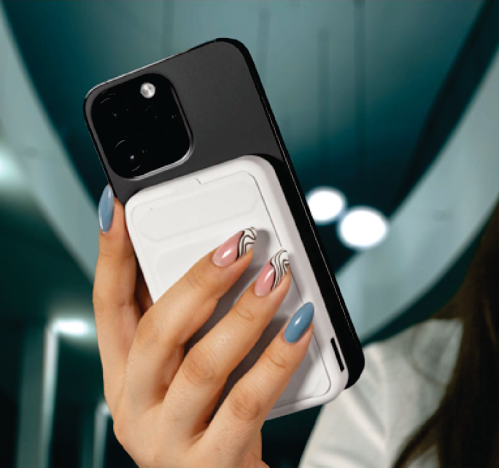 Person holding a smartphone with a black case and white card holder, showing manicured nails in blue and pink with designs.