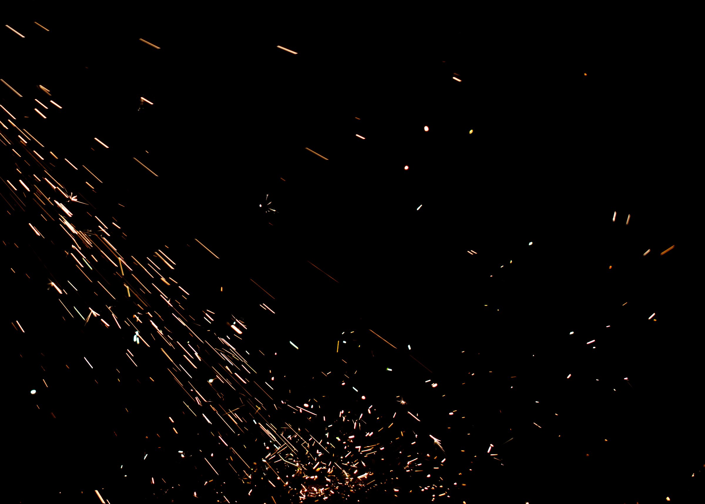 A black background with a lot of sparks and fire. The sparks are falling from the sky and are scattered all over the background. Scene is intense and chaotic