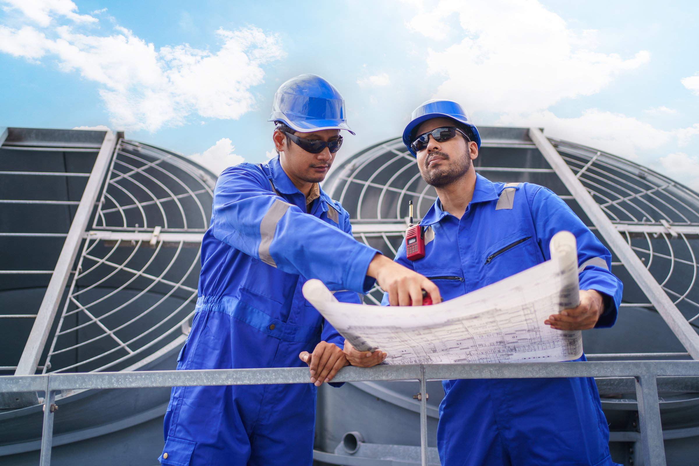 Engineers and maintenance technicians inspect the HVAC ventilation and cooling system on the rooftop of a high-rise building, ensuring air conditioning performance and safety.
