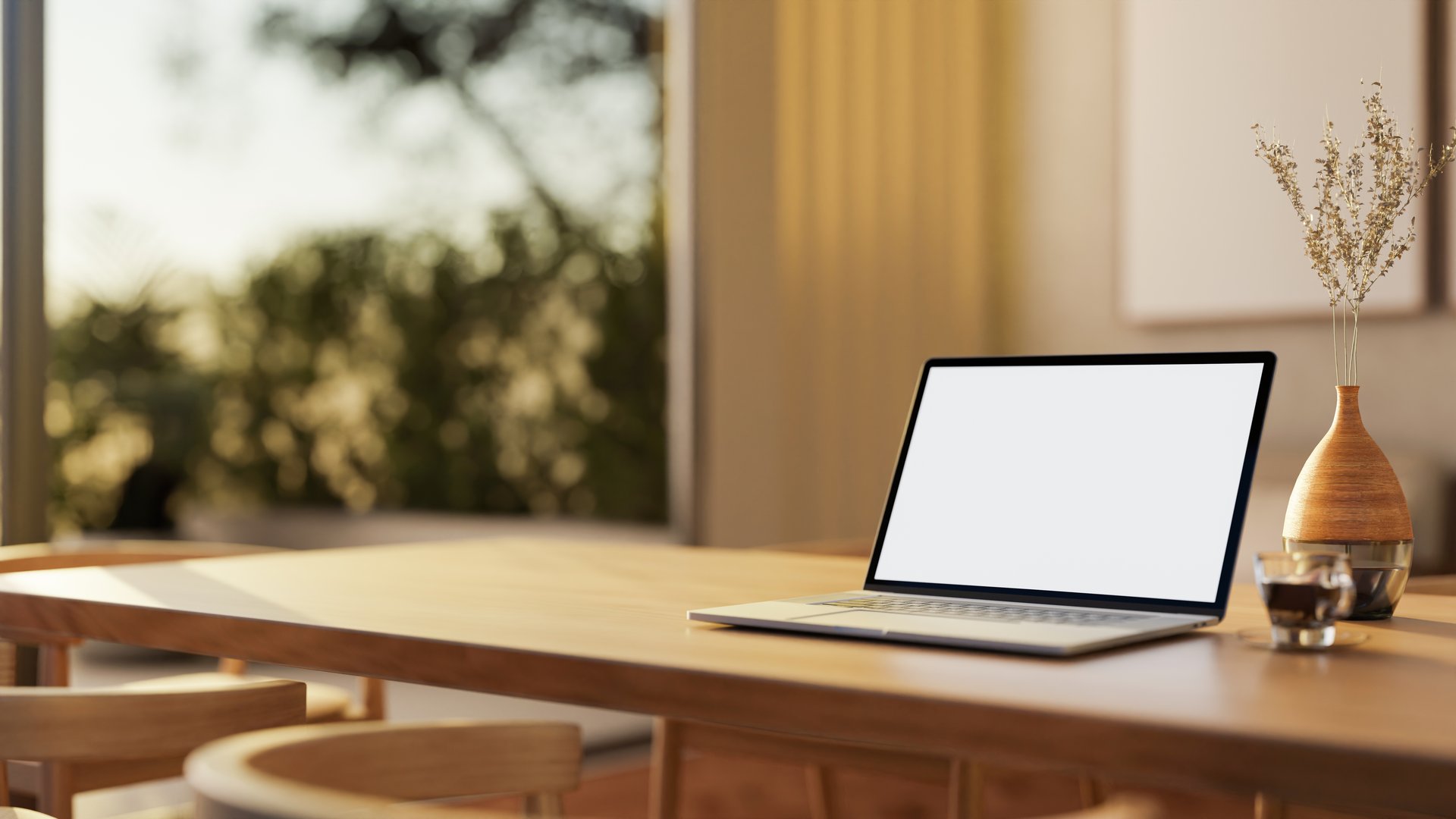 A close-up of a laptop with a white screen mockup on a hardwood dining table in a contemporary home, illuminated by stunning natural light. 3d render, 3d illustration
