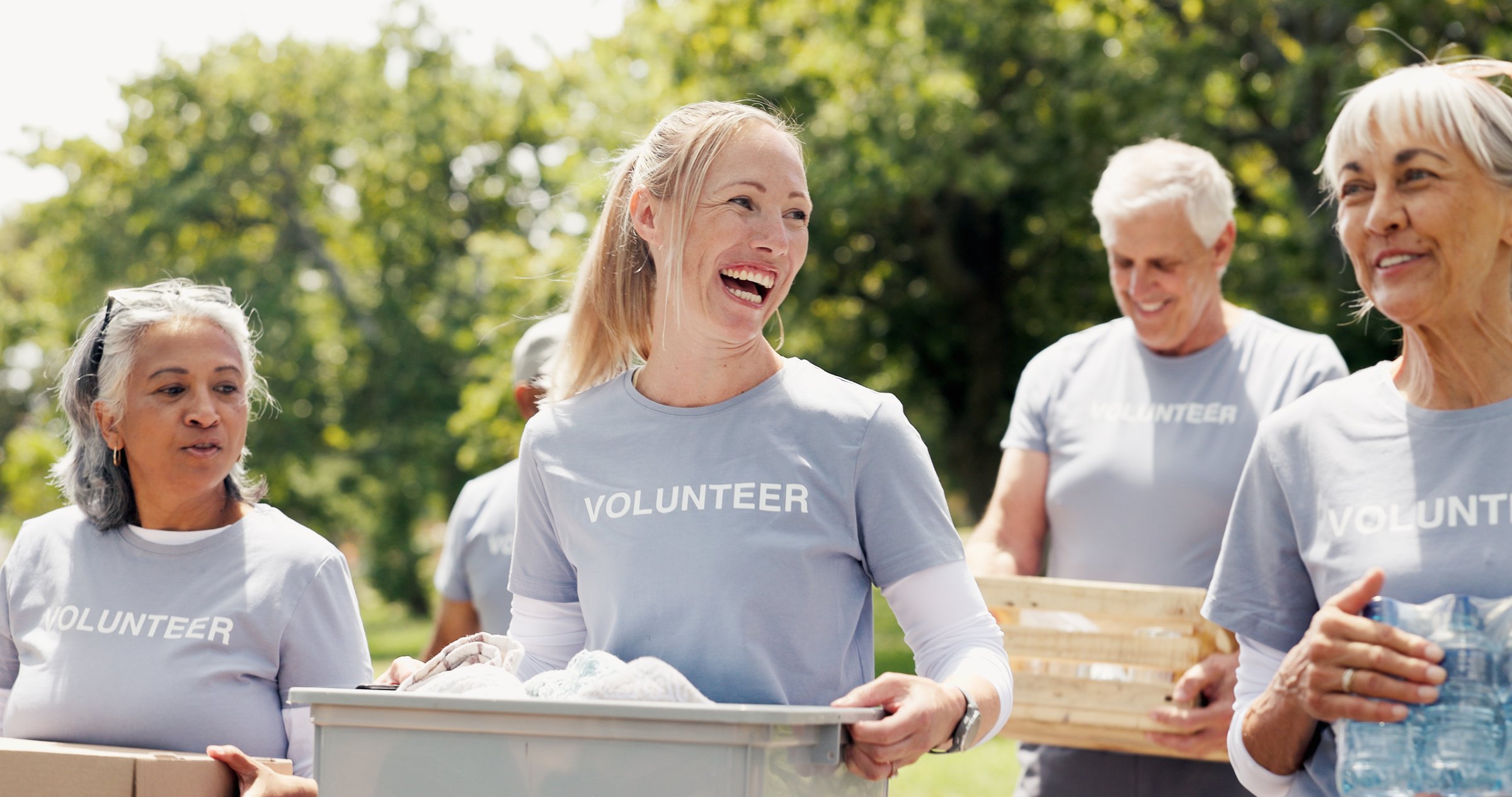 Volunteer, walk or people in park with donations, conversation or collaboration in relief campaign. Laugh, teamwork or group outdoor with stroll, discussion or distribution in food drive project.