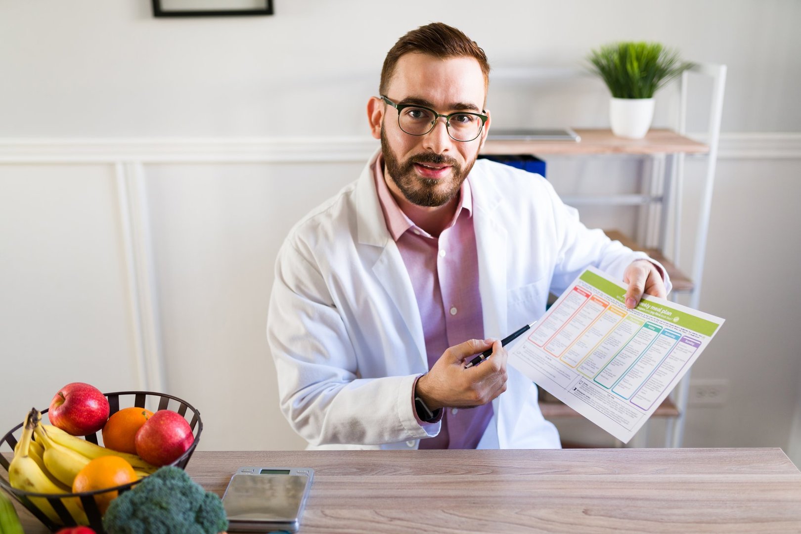 Portrait of a professional nutritionist giving a healthy diet to a patient at his office who wants to lose some weight