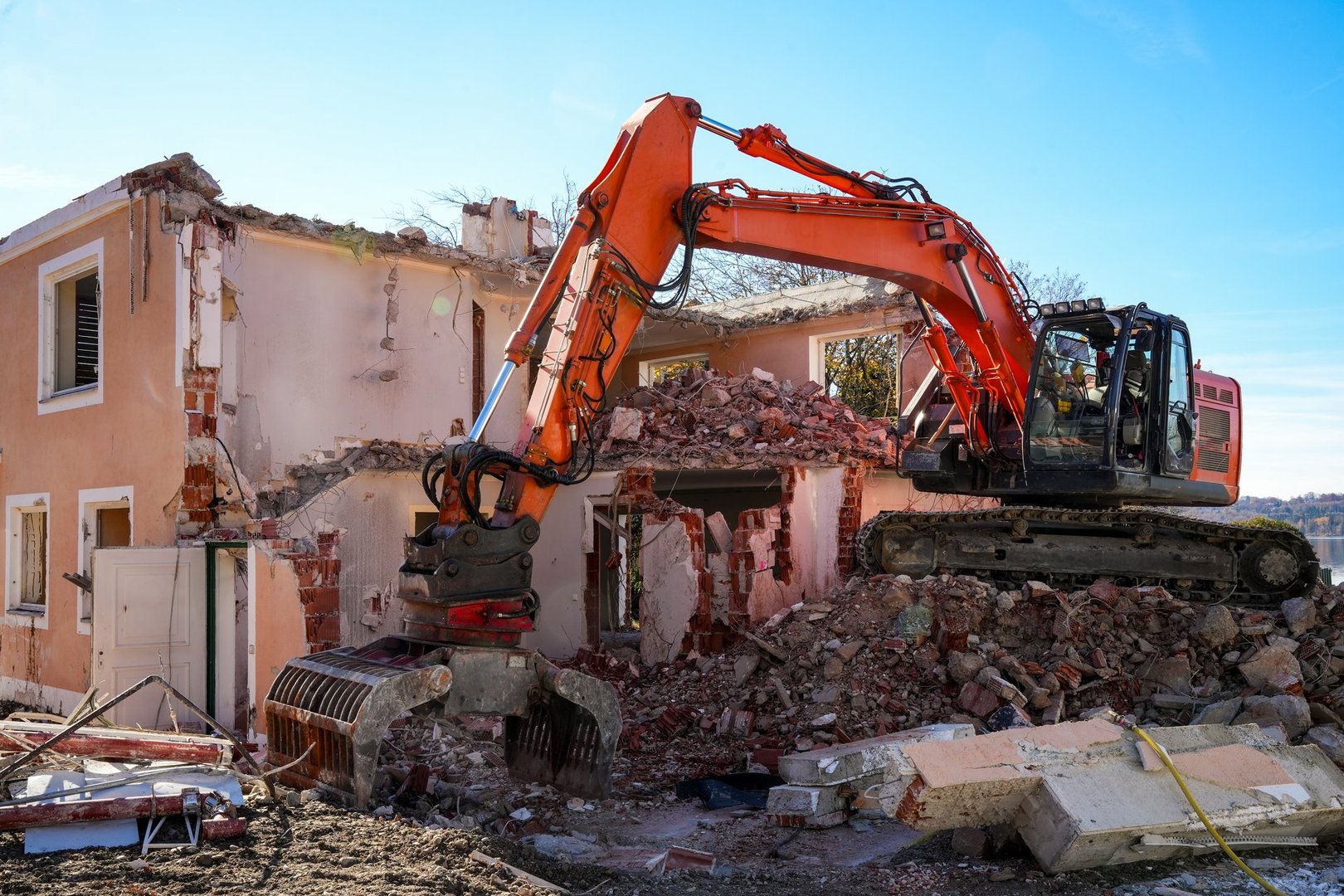 Excavator demolishing old building on construction site