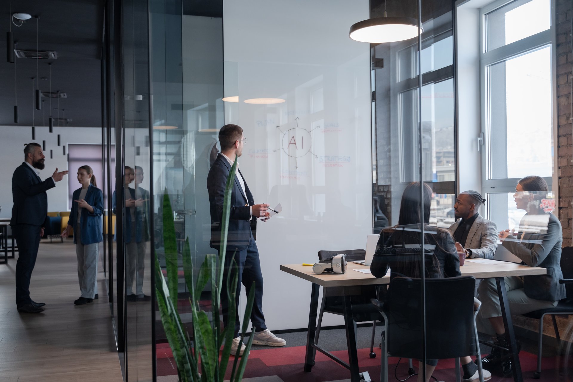 Modern office meeting with diverse professionals discussing artificial intelligence strategy. Concept of teamwork, technology, and corporate innovation in a contemporary workspace.