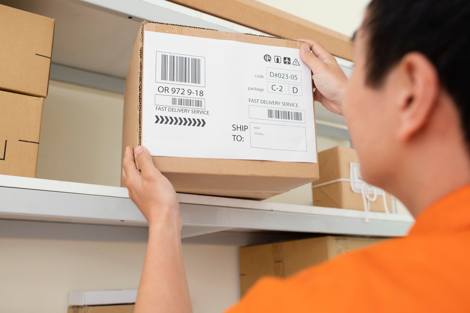 Close up of young man taking box from shelf