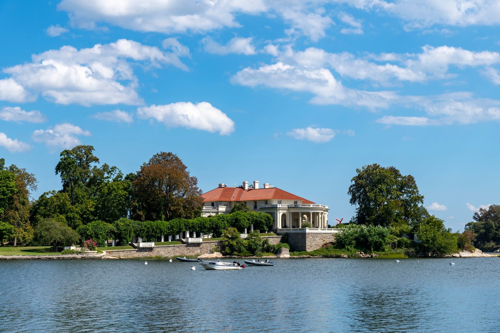 Greenwich, CT, USA-August 2022; View over the water of Greenwich Harbor towards Indian Harbor Point with one of the large waterfront residential properties