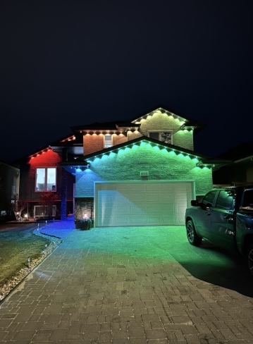 Large two-storey Saskatoon home roofline illuminated with clean warm-white permanent lighting