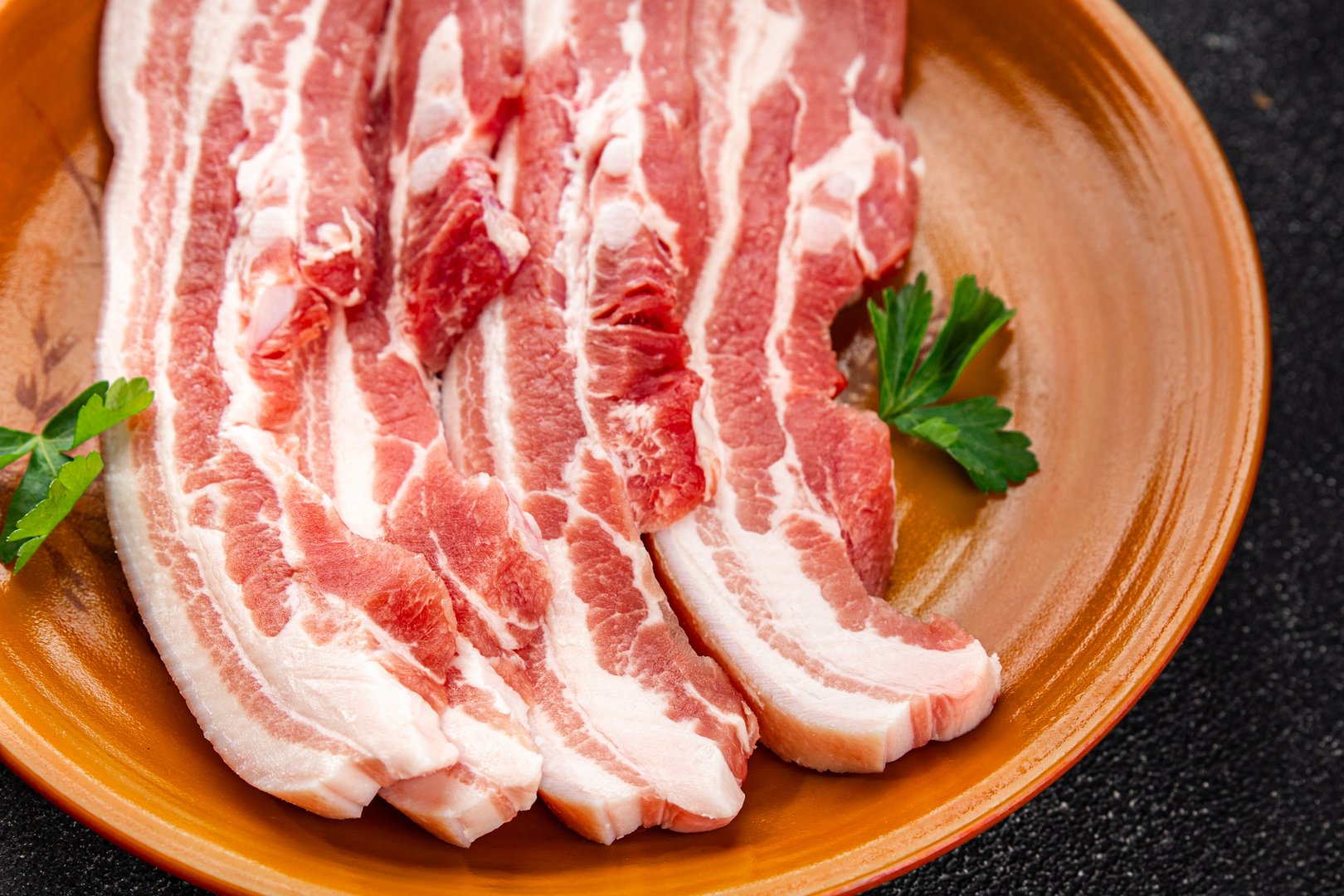 Bacon slices pork meat fresh delicious gourmet food background on the table rustic food top view copy space