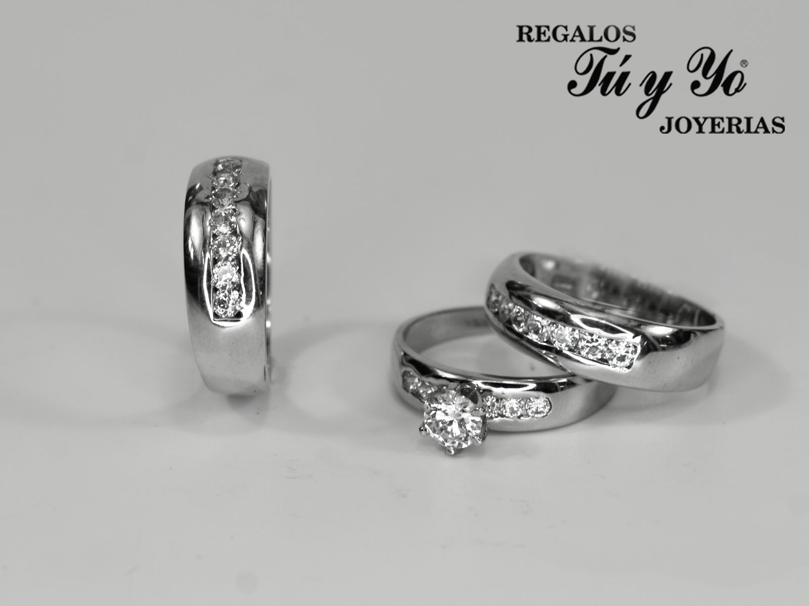 Three silver rings with diamonds on a white background, featuring "Regalos Tú y Yo Joyerías" in the corner.
