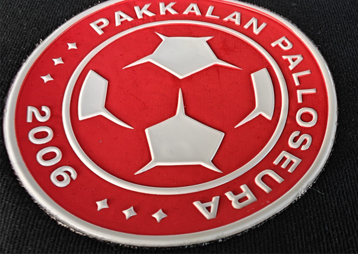 Red and white Pakakalan Palloseura football club logo with stars and the year 2006 on a dark background.