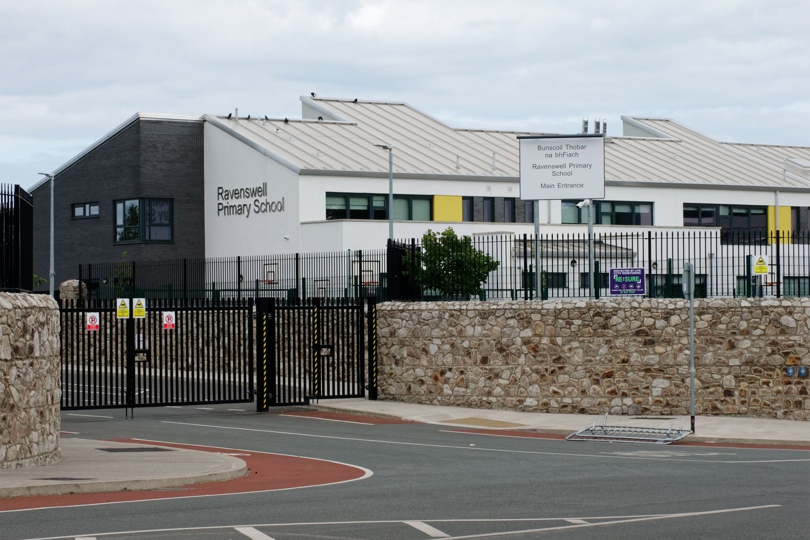Bray, Ireland – August 06, 2022: Ravenswell Primary School building seen across an empty street on cloudy summer day.