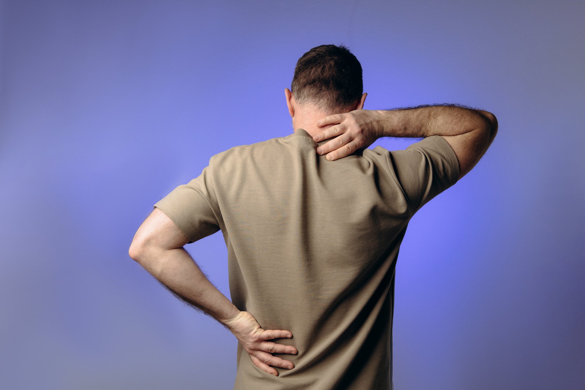 man experiences back neck pain due to age-related changes, osteochondrosis, herniated discs or chronic spinal diseases. Prevention of spinal problems, therapeutic exercises, physiotherapy.