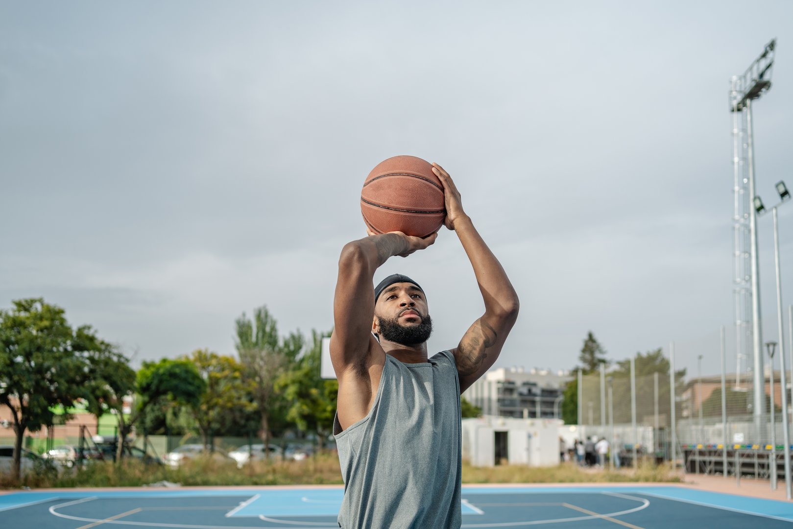 Focused athlete is practicing basketball outdoors, preparing for a game with dedication
