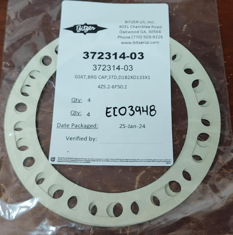 Plastic packaging with circular metal gasket and product details on a label, including a part number and packaging date.