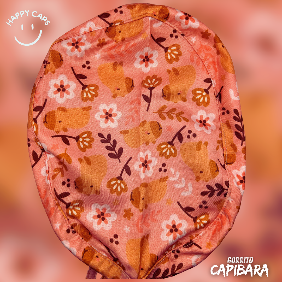 Pink cap with capybara and floral pattern, Happy Caps logo and Gorrito Capibara text in white.