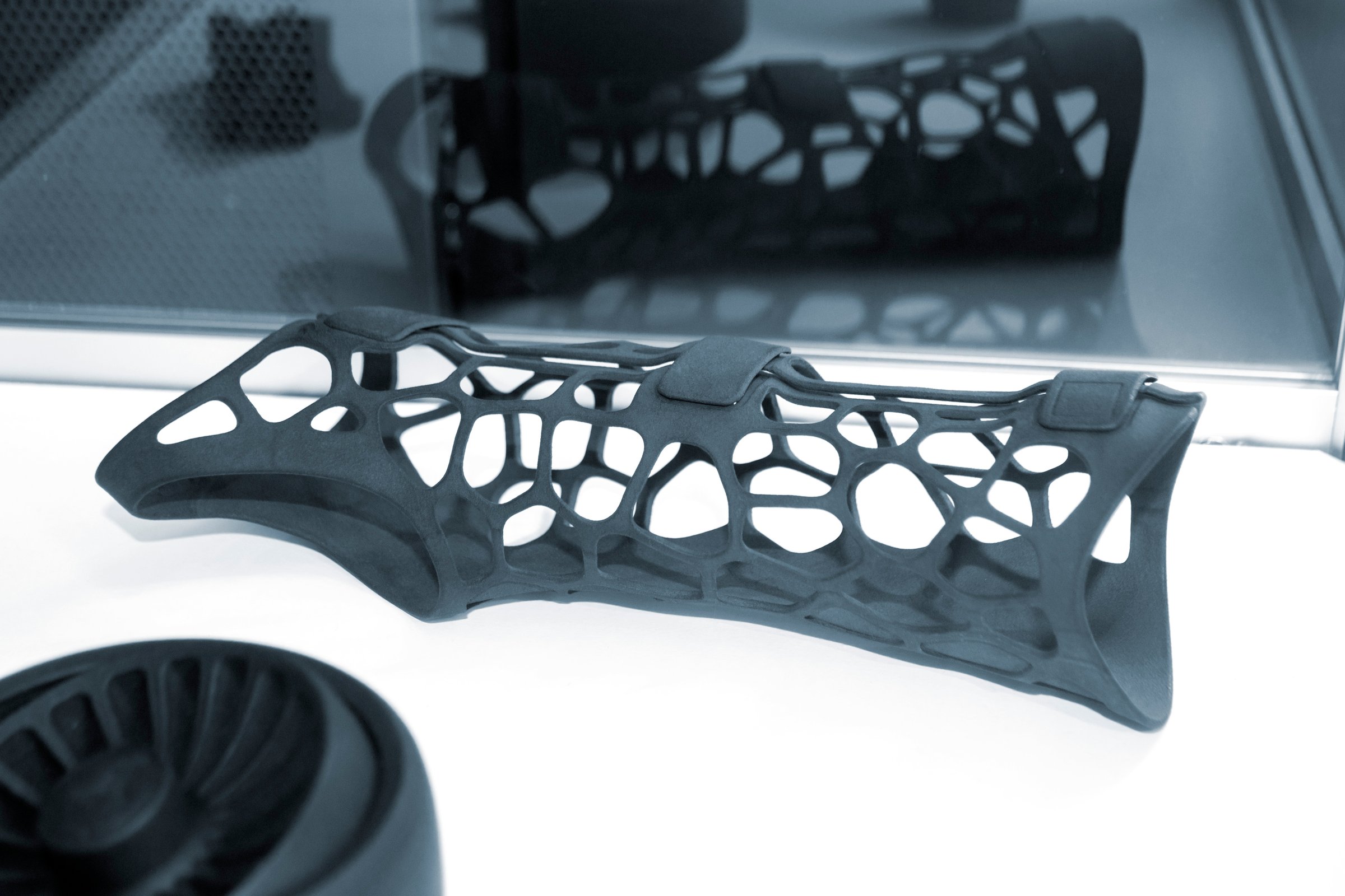 Black orthopedic plastic prosthesis printed on powder 3D printer for hand. Orthopedic gypsum helmet close-up. Multi Jet Fusion MJF 3D printing technology. New modern progressive additive technology.