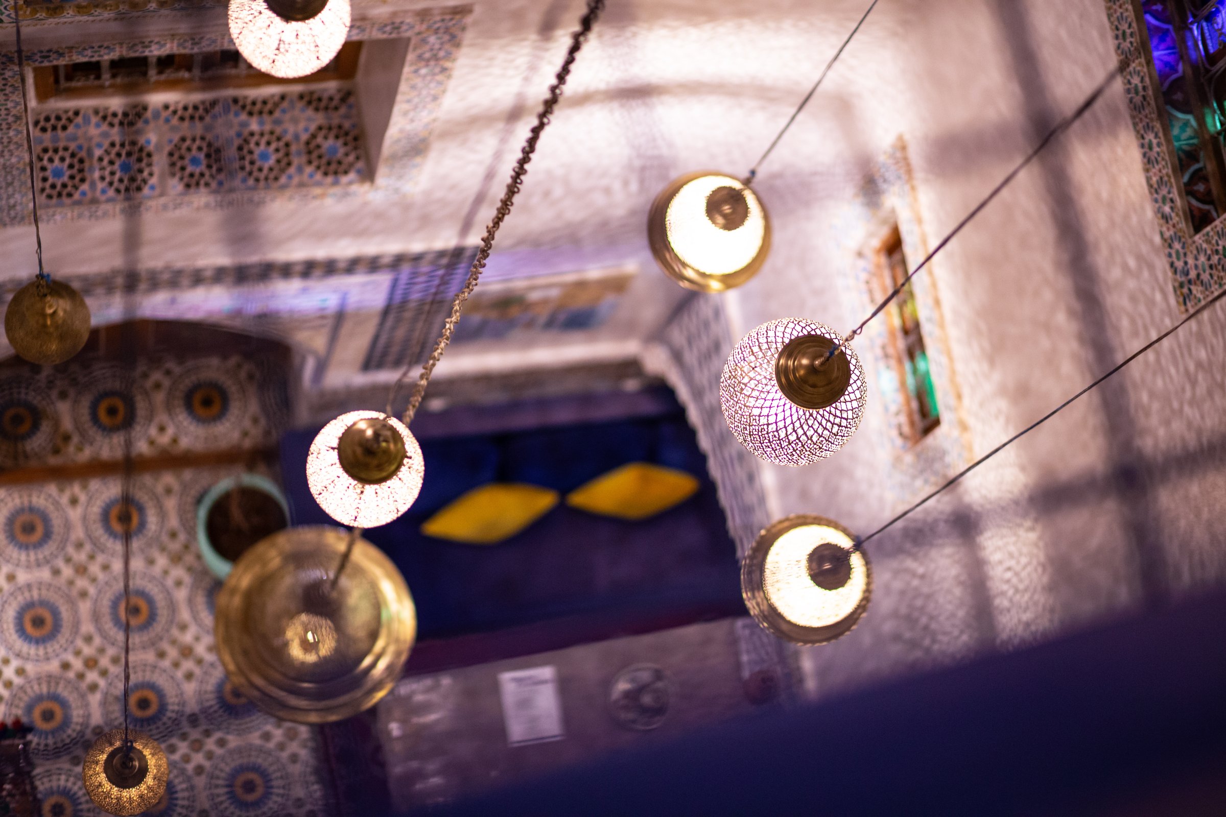 Beautiful decoration lamps hanging from the roof in the interior patio of a Riad building in Fez, Morocco