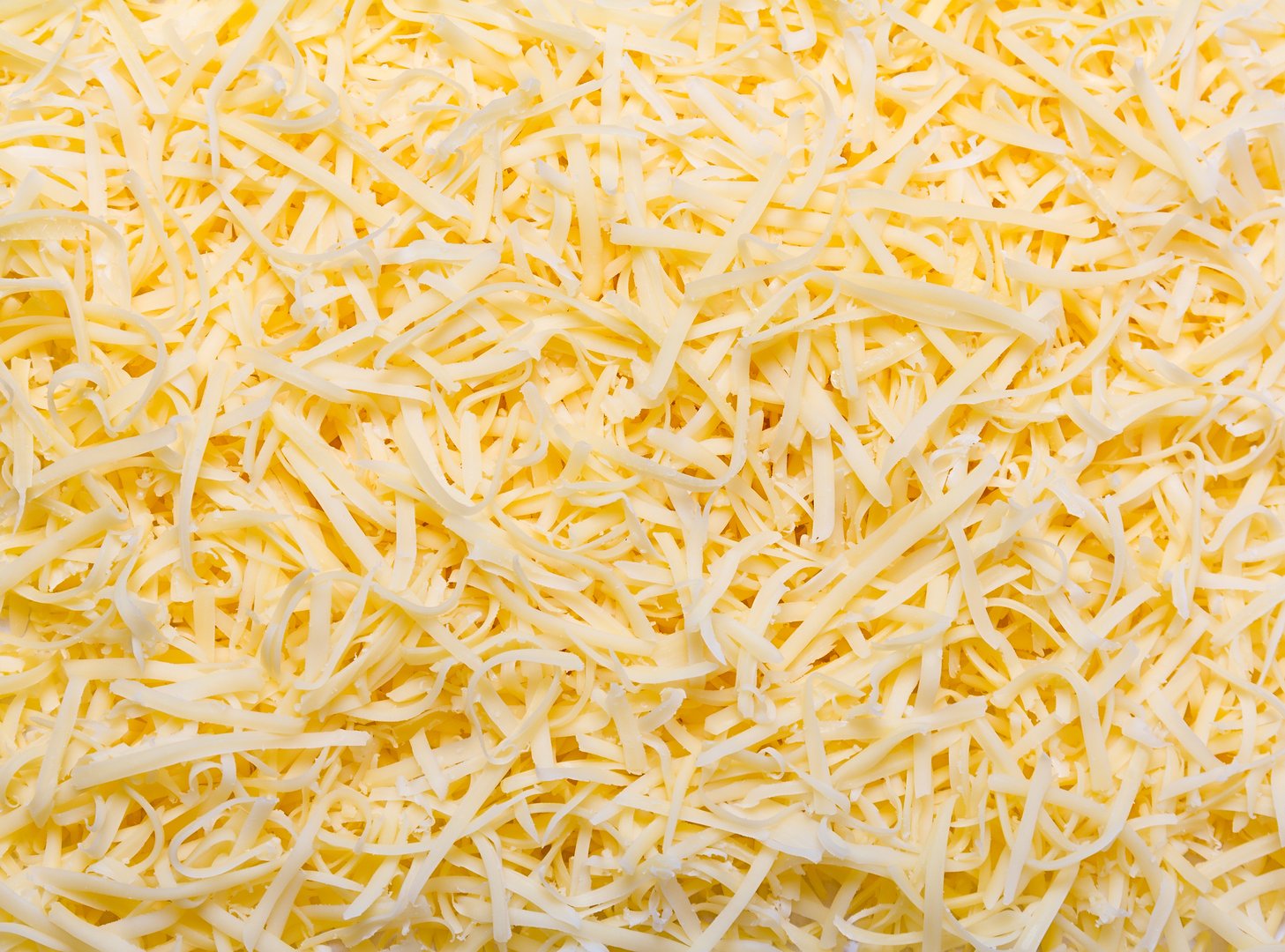 Heap of Grated pizza cheese close up texture