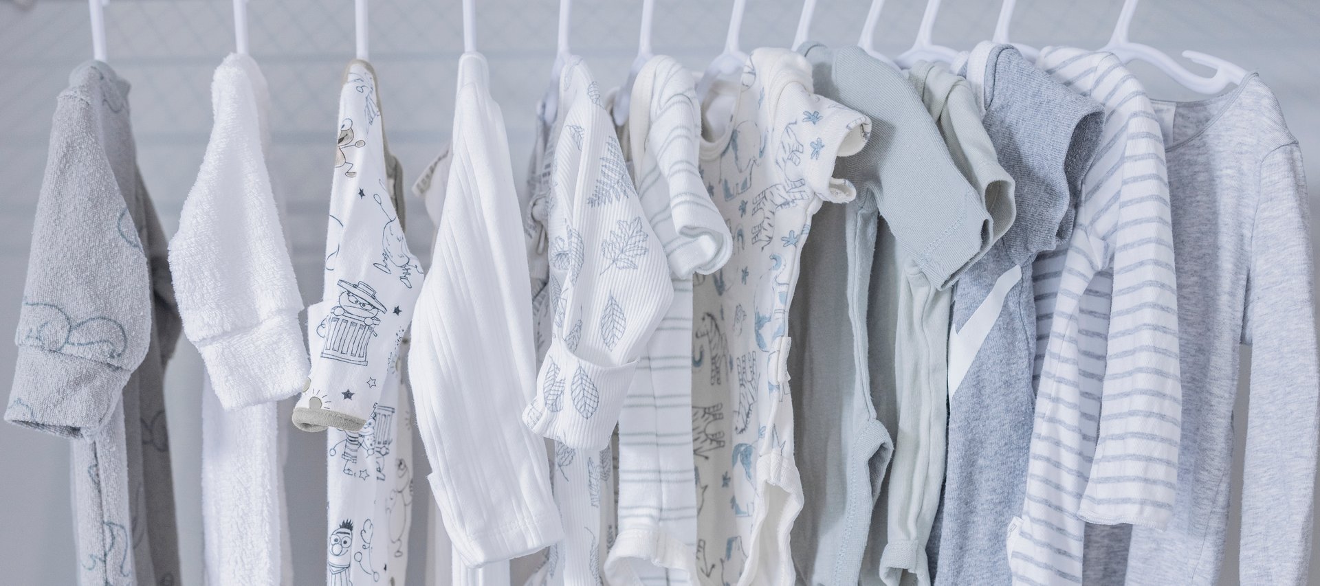 Baby clothes in a wardrobe on children's hangers