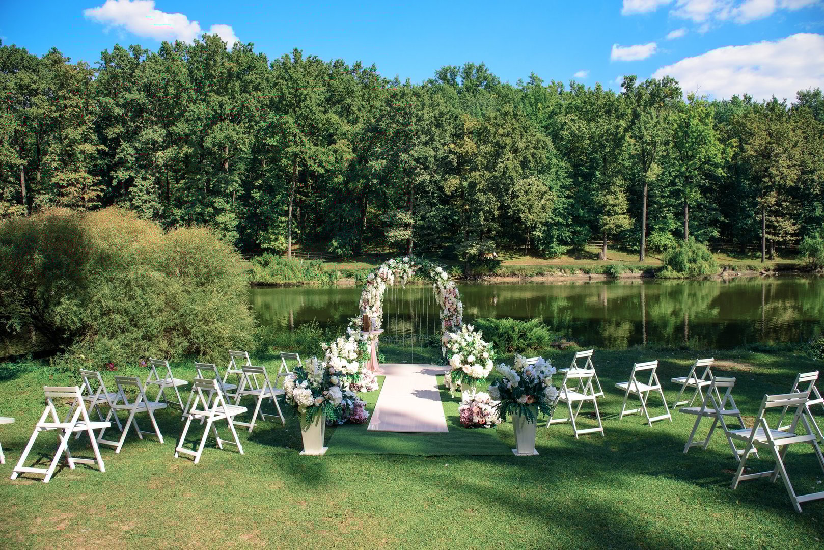 Arch of wedding registration on the background of a lake in the forest.