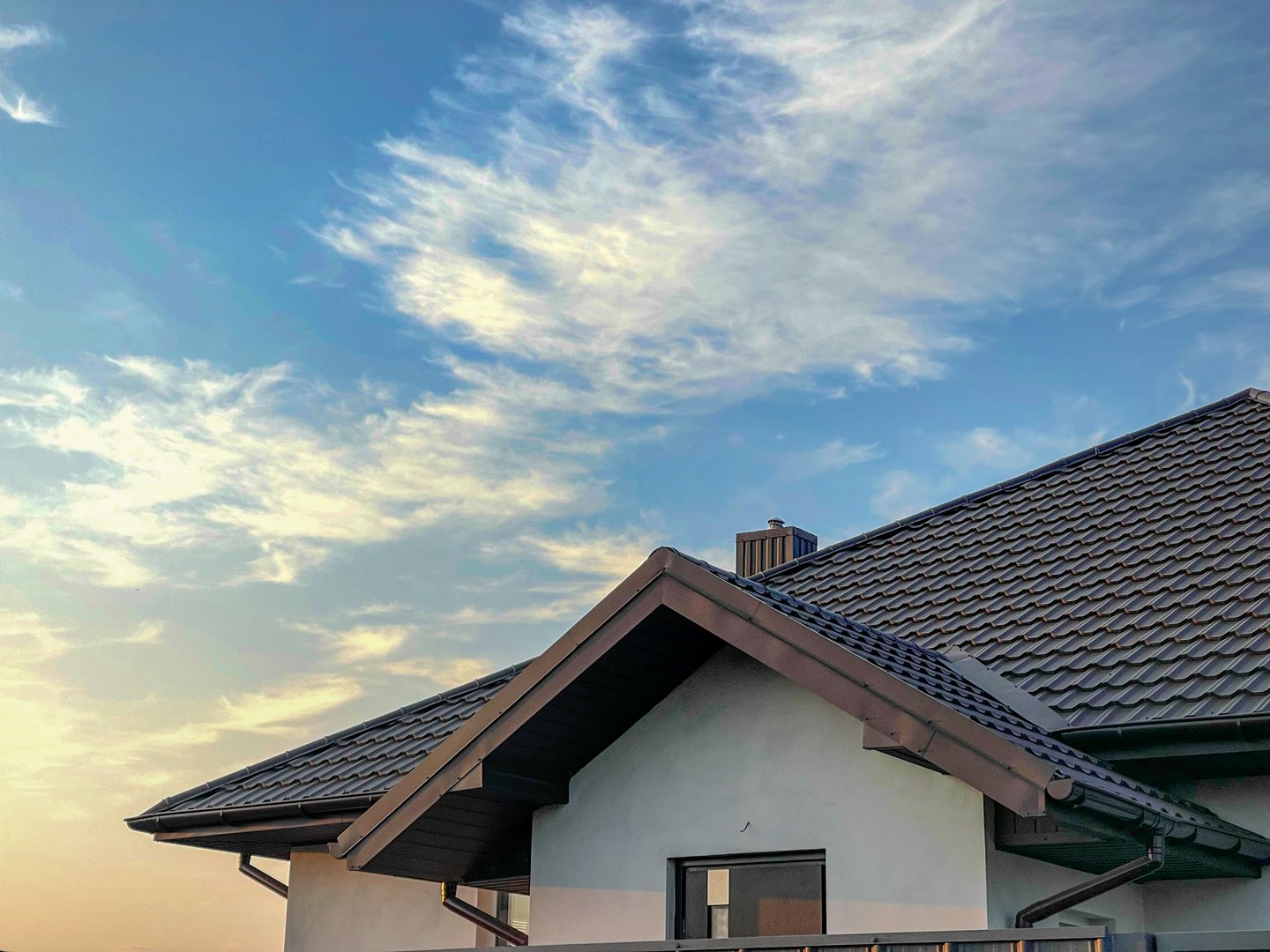 The slope of a metal roof against a blue evening sky