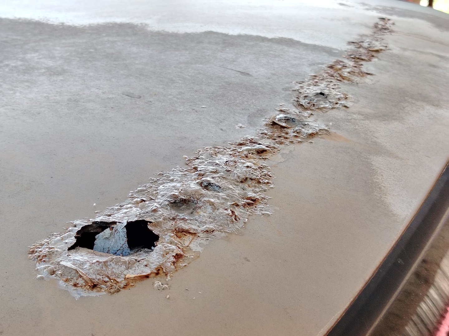 Car roof top with holes, rusty and decay. Old car roof.