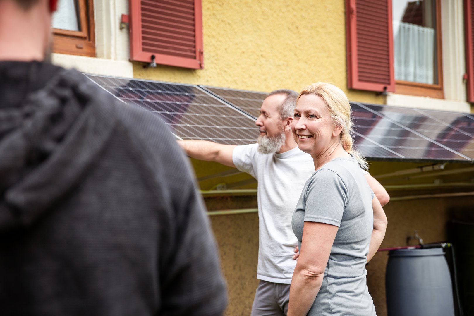 an electrician and specialist explains a newly installed pv system to customers