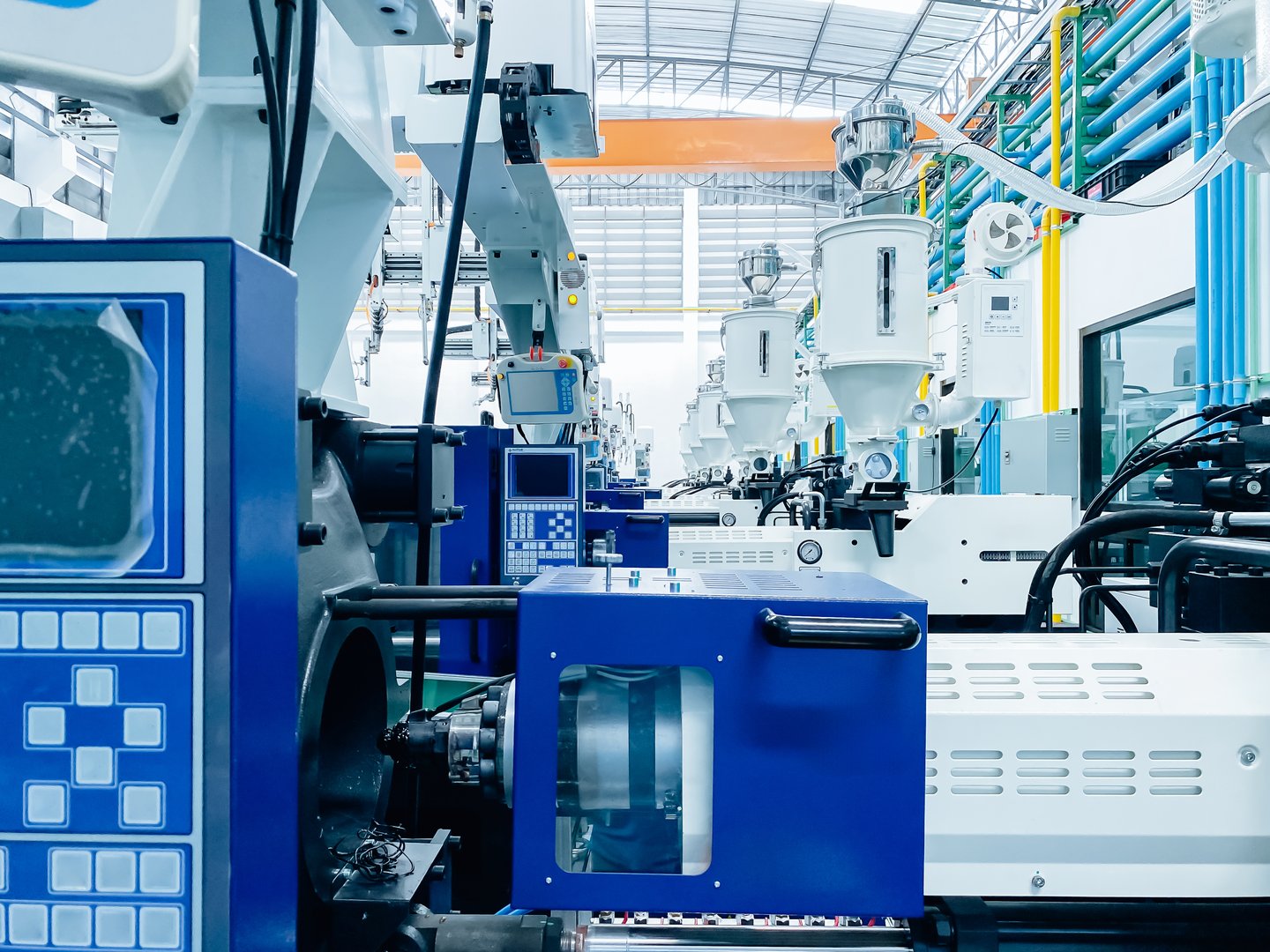 High-tech plastic injection molding machines lined up in a modern factory. machines are arranged neatly.
