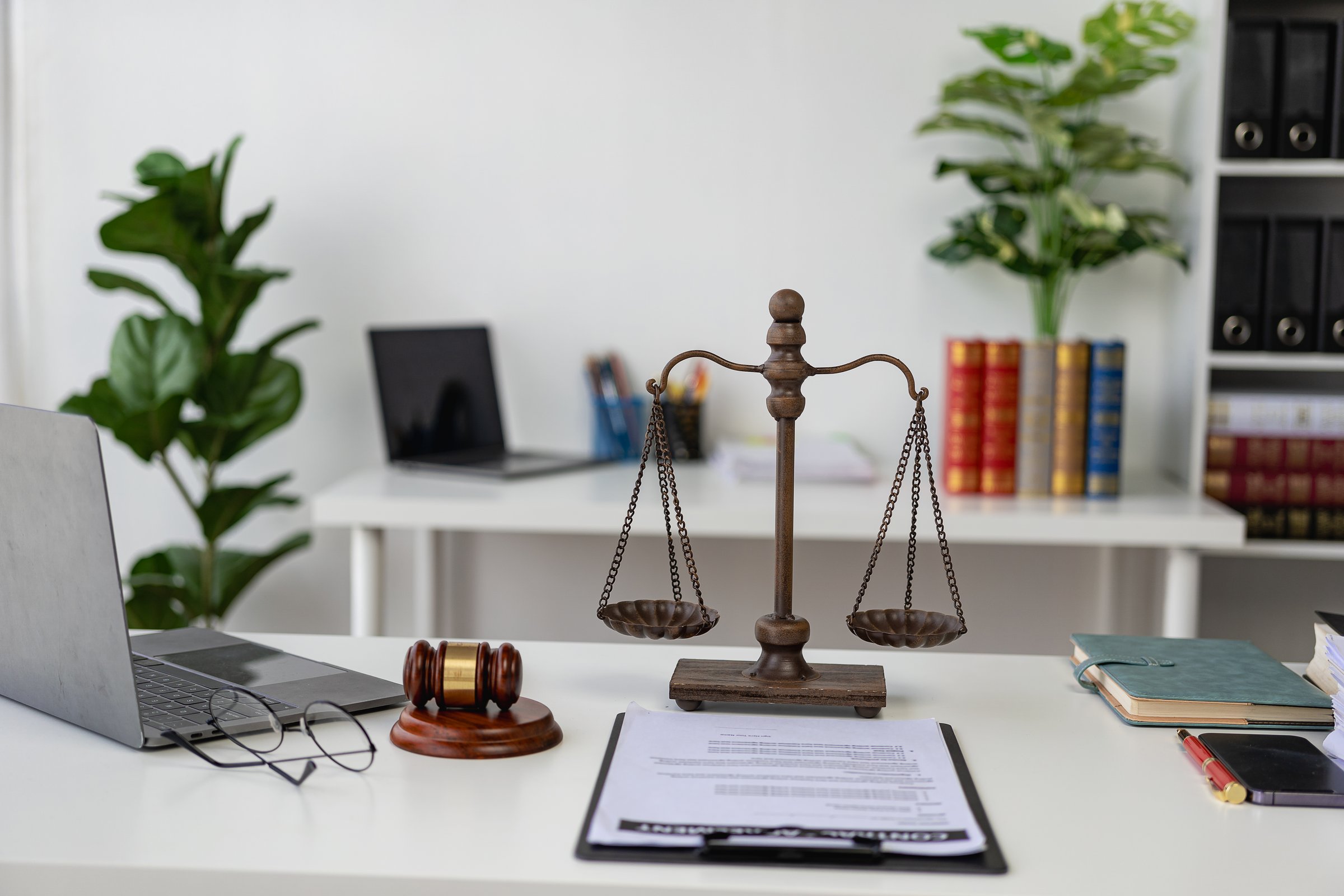 Judge's gavel, legal scales and books on black background. Legal concepts regarding judiciary and justice Justice concept at workplace of lawyer with laptop
