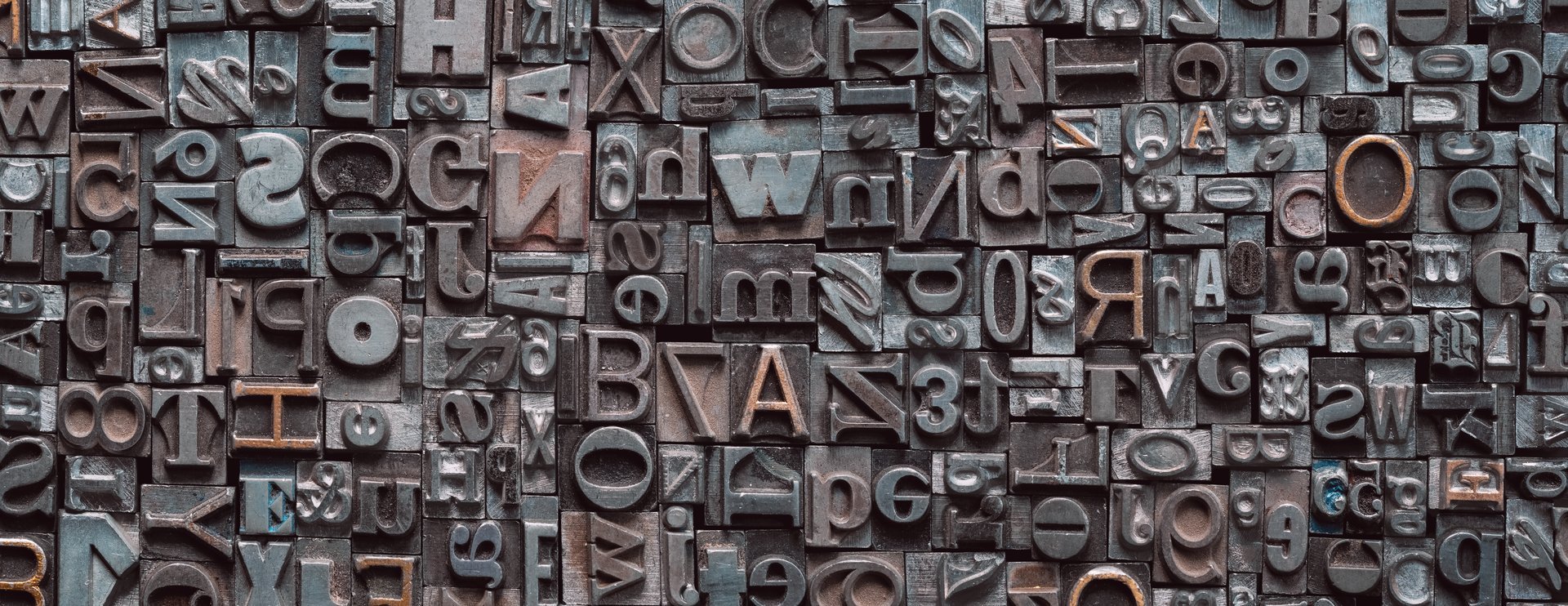 Letterpress background, close up of many old, random metal letters with copy space