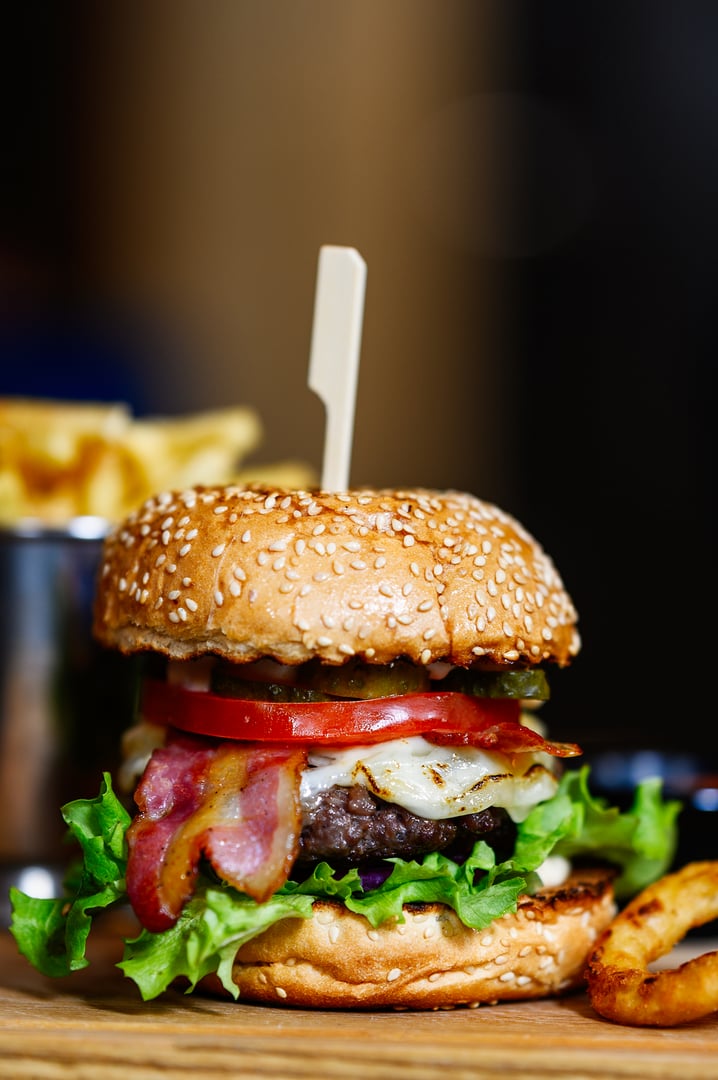 beautifully served burger and fries on a wooden board on the restaurant table