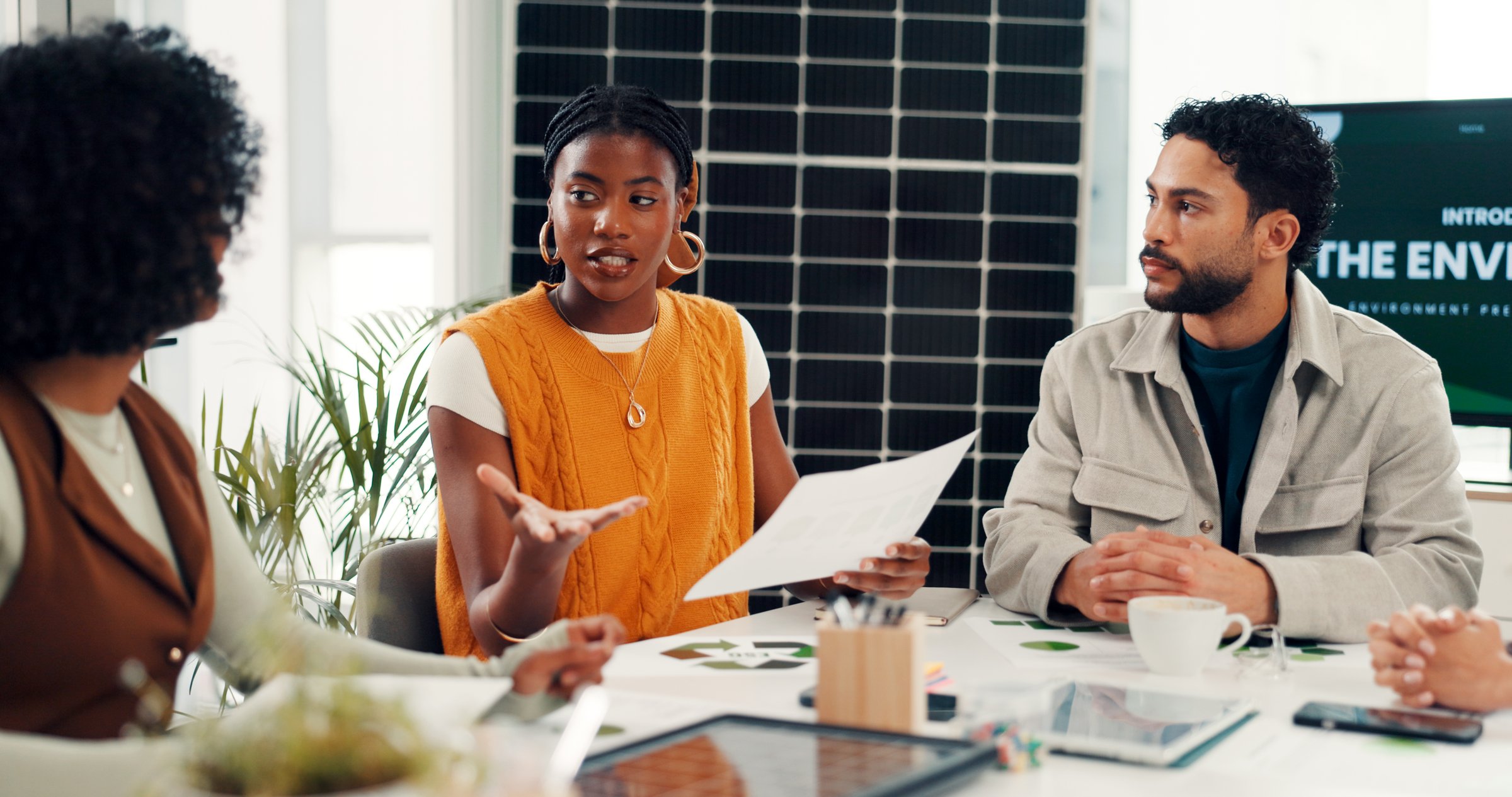 People, documents or meeting in office for sustainability, clean energy plan or photovoltaic system. Team, paperwork or conversation in workplace with solar panel, eco friendly idea or SDG compliance