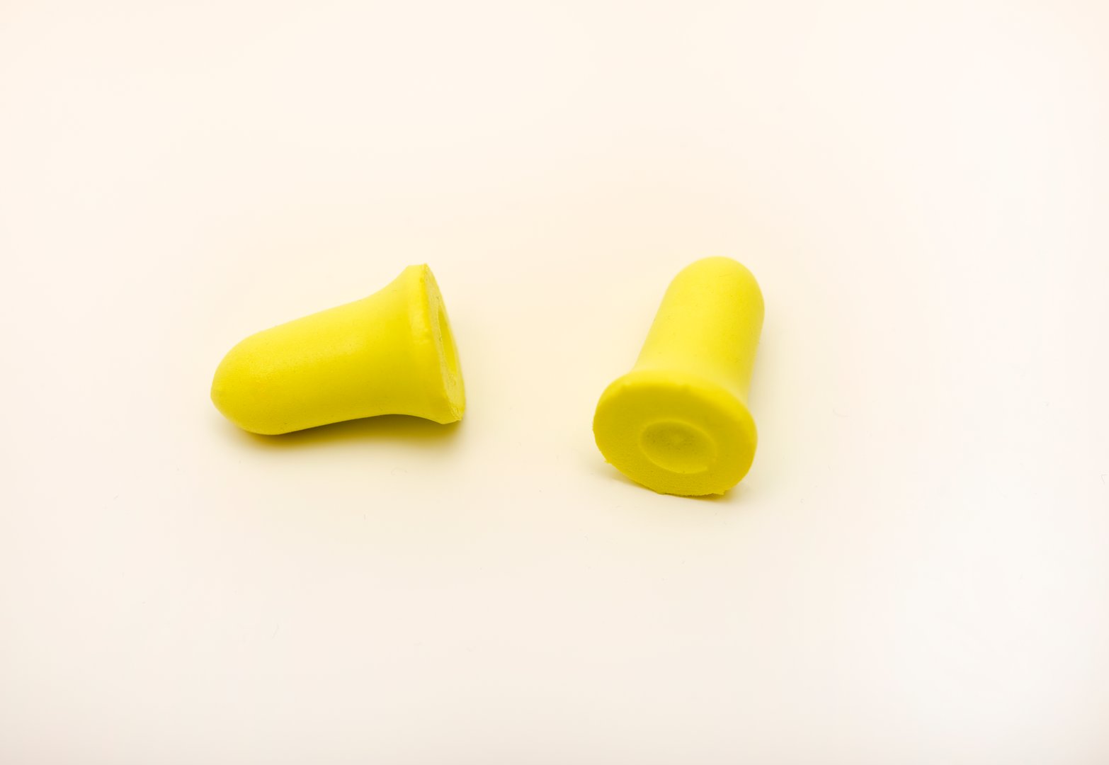 Yellow earplugs on a white background. Hearing protection products.